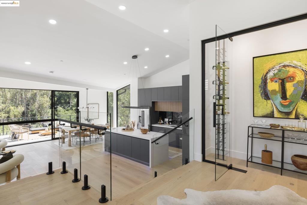 Step into a world of striking architecture and radiant light in this brand-new 4+ bedroom, 3 bath home nestled in desirable Montclair. From the moment you enter, dramatic ceilings and expansive windows create a breathtaking first impression. The main level features a sweeping open layout designed for contemporary living and stylish entertaining. A state-of-the-art kitchen with a sleek island anchors the space, flowing effortlessly into the dining area and family room. Glass doors open wide to a grand deck—perfect for seamless indoor-outdoor living. A glass-enclosed wine closet serves as a showpiece, ideal for displaying your favorite bottles, collectible spirits, or even a curated selection of art or memorabilia. A spacious guest suite with a full bath offers comfort and privacy on this level. Downstairs, a cozy lounge area connects three bedrooms and two full baths, creating an ideal retreat for family or guests. The primary suite is truly a work of art, complete with a spa-like bath featuring a soaking tub, oversized shower, private view deck, and a generous walk-in closet. Experience elevated living in one of Oakland’s most sought-after enclaves; where architecture inspires and every detail elevates with bold design, refined comfort, and a lifestyle that rises above it all.