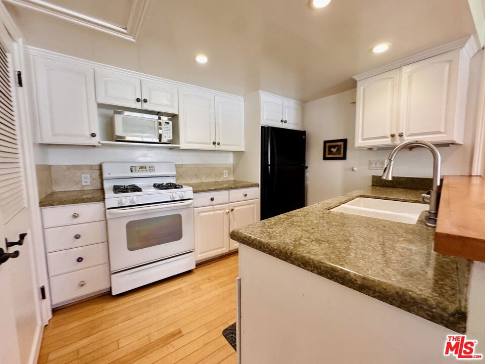 Location, location... LOCATION! Welcome to Stratford Terrace! A quiet, well-maintained community located at the end of a peaceful cul-de-sac in the heart of Canoga Park! This ground-level 2 + 2 condo features a functional open layout with hardwood floors and recessed lighting throughout most of the unit! Enjoy two primary bedrooms, each with its own en-suite bathroom and generous closet space! In-unit stackable laundry! An open kitchen! And step out to your private patio and small yard which offer a great space for pets, gardening, or relaxing outdoors! Two assigned covered parking spaces. Community Pool! Controlled gate access! And plenty of guest parking! Ideally located just minutes from Westfield Topanga Mall, Topanga Village, Warner Center Park, and a wide array of shopping, dining, and entertainment options!