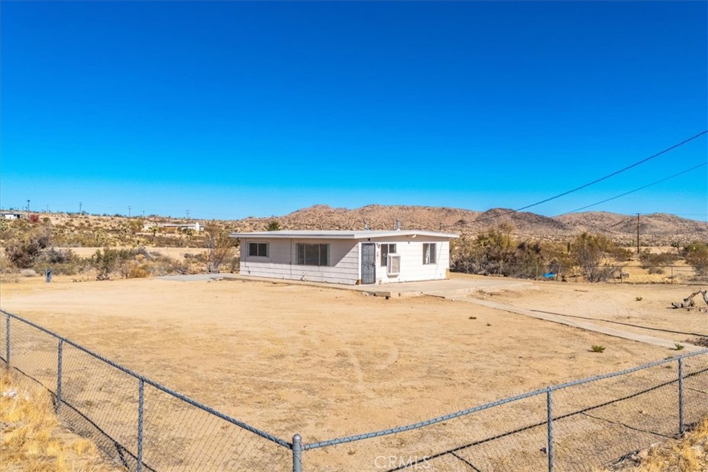 Amazing Opportunity to own this 1960's 2 Bedroom 1 Bathroom Desert Pad In Yucca Valley and Minutes From The Joshua Tree Village and National Park! On the drive in you'll immediately realize this property's potential based on the convenience of the location being located within a short walk to shopping and dining as well as a quick drive to downtown Joshua Tree and the National Park! Pulling up to the large fenced in 1.07 acre lot you get a glimpse of the type of property that people have sought out Hi-Desert Real Estate for! With it's 1960's desert design it's a perfect open canvas for you to come in and make it your own! Walking through the front door you'll find tile flooring that flows throughout as well as plenty of natural light coming in from the windows! The kitchen has a good amount of space for your culinary delights featuring freshly painted cabinetry as well as room for a dining table and chairs! The full bathroom is equipped with bathtub.shower, vanity, and commode! Both bedrooms are good sized and include open closets and windows that have some nice views! Perfect for full time, 2nd home, or rental! This one is priced to sell and won't last long so call for your private showing today before it's gone!