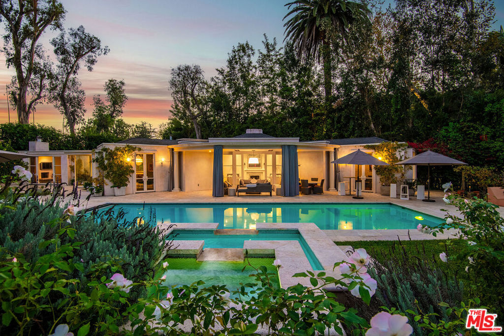 Nestled in the prestigious enclave of Lower Bel Air, 101 Bel Air Road offers a rare opportunity to own a meticulously reimagined, one-story estate on nearly an acre of lush, flat land. With approximately 4,731 sq. ft. of beautifully designed living space in the main house, this private, gated residence designed by Goldman/Firth Architects offers a serene retreat with exceptional indoor-outdoor flow, perfect for both elegant entertaining and relaxed living. The expansive lot offers approx. 39,751 sq. ft. of idyllic gardens with thriving grapevines, various fruit trees, plentiful gardens, winding paths, and manicured lawns, all enhanced by tranquil fountains and peaceful water features. A large motor court with ample parking adds convenience to this private oasis, while covered and open patios surround the property, offering countless places to enjoy the beautiful Southern California weather. The heart of the home is the sophisticated formal living room with a striking fireplace, providing a welcoming ambiance that flows seamlessly into the formal dining room. A modern gourmet kitchen is a true chef's delight, featuring professional-grade appliances, a large eat-in island, and high ceilings with a skylight to invite the warmth of morning sunlight. The kitchen opens into a spacious family room with its own fireplace, making the space ideal for both intimate gatherings and lively entertainment. The luxurious primary suite is a sanctuary of its own, complete with a cozy fireplace, a custom walk-in closet, a spa-like bathroom with premium finishes, and an adjoining office. For added comfort and convenience, the estate includes a fully equipped gym. The main house also offers two additional family or guest bedroom suites and a powder room. Additional structures on this property include a detached guesthouse offering two bedrooms and two bathrooms, perfect for visitors or as private workspaces. Additionally, a detached media and billiard room provides an exceptional setting for movie nights or game days. Designed for ultimate privacy and enjoyment, the outdoor spaces feature a sparkling pool, a rejuvenating spa, and a firepitperfect for year-round relaxation or entertaining under the stars. There is also a custom-built dog run at the back of the property to protect your precious pets. Originally built in 1947, the home has been thoughtfully updated to offer modern amenities while retaining its timeless charm. A true gem in one of Los Angeles' most coveted neighborhoods, 101 Bel Air Road offers the perfect balance of luxury, privacy, and tranquility.