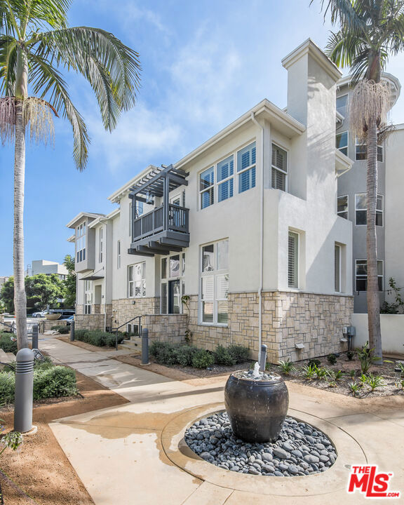 This Playa Vista split-level townhome is situated in a serene courtyard surrounded by lush landscaping and tranquil fountains, located in the Tapestry II community. The private walk-up entry brings you into an expansive living room with ultra high ceilings, abundant windows, and a cozy fireplace. A few steps up reveals an open dining/family room, a powder room, and a kitchen with a balcony and pantry. Additionally, a separate space that can be used as a sitting area or for dining. The top level has a luxurious primary suite with high ceilings, a walk-in closet, a cozy fireplace and a relaxing balcony. The spa bathroom has a soaking tub, double vanities, a water closet, and a large shower. The second bedroom has its own en-suite bathroom. This home has a private 2 car garage, a laundry room, and a downstairs flexspace a few steps down from the living room that can be used as an office, a rec room, or a 3rd bedroom. Recent upgrades include Philips lighting, a water filtration system, balcony resurfacing, and a new HVAC system and water heater. The Tapestry II community is perfectly situated close to a Whole Foods, coffee shops, restaurants for all tastes, boutiques, lush parks, sport courts, a Cinemark and The Resort which is a resident-exclusive state of the art fitness center with sparkling pools. Playa Vista HOAs include 2 resident-exclusive fitness centers, pools, lush parks, a beach shuttle, sport courts, community security, and the list goes on. Come see what everyone is talking about!