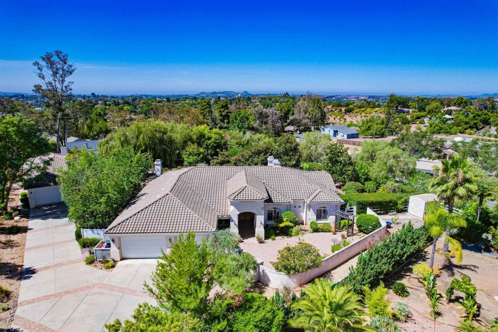Two beautiful single story homes, totaling 4360 sqft, on one acre of fully landscaped and hardscaped grounds, at the end of a private cul de sac. No HOA. What sets this property apart is as follows: #1 It is extremely rare to find a guest house or ADU in Fallbrook/Bonsall with 1,000 sqft, a full kitchen and an attached garage. Custom built with the same quality of the main house, it provides an immediate opportunity for multigenerational living or to earn monthly rental income. #2 Original owners, first time on the market, the main home, 3360 sqft built in 2003, is meticulous, designed to enjoy the indoor and outdoor lifestyle of picturesque Fallbrook. #3 The sellers made a significant investment surrounding both homes in extensive hardscaping and mature landscaping, so that you don’t have to. #4 Solar, covering both homes, is fully paid for with 47 panels. #5 At only $389 per sqft, it’s priced lower per sqft than competitors with permitted and nonpermitted ADUs. Don’t miss this opportunity. The open layout of the main home is complimented by high ceilings throughout. The spacious living room and dining room has a fireplace, built-in shelving, and a wall of french doors with views of the lush gardens beyond. The kitchen has a breakfast bar and dining area that opens to an oversized family room with dry bar and fireplace, ideal for entertaining. The primary bedroom has a fireplace, views of the gardens, a covered patio, a master bath with dual vanities, a garden tub, walk-in shower, and a large walk-in closet with skylight. Two secondary bedrooms share a Jack and Jill bathroom with views of the gated paver stone courtyard. The guest bedroom or den, has a separate entrance with a covered porch, and a private door to the guest bathroom. 3 car finished garage, dual A/C, circulating pump. Both homes feature double ovens, bosch dishwashers, 5 burner gas stoves, keyless entry, central vacuum, oversized laundry rooms with deep sinks and a plethora of cabinet space. The guest house lives like a home because it is one, fully permitted as a Second Dwelling. It sits outside the fencing of the main house, and has its own driveway and walkway. Mature landscaping provides privacy between the two homes. Live next to parents while providing them with independence, or rent it for additional monthly income, or use it as an AirBnB to take advantage of the area’s many wedding venues. Custom built in 2004, the guest house boasts a large chef’s kitchen with granite counters, custom cabinetry, and a breakfast bar. The livingroom has a fireplace, and both the diningroom and bedroom have glass sliders that open to a private covered patio. The bedroom has a large walk-in closet, nook designed for a work space, bathroom with make up vanity, walk-in shower, and jacuzzi tub. The guest house enjoys its own yard with a 3 hole putting green, beautiful landscaping, fruit trees, and small vegetable garden. The main home is fully fenced with walking paths that wind through fruit trees, gorgeous waterwise landscaping, and redwood garden boxes. The outdoor living space boasts 3 covered patios, a built-in BBQ with bench seating, firepit, and a tranquil fountain. A large shed on a concrete foundation provides extra storage and the gated dog run/yard is also landscaped.