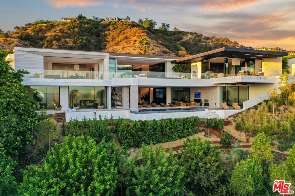 One of the most iconic architectural homes has reached the finish line following an exciting 6 year development. With impeccable design by Luxford Group and world-renowned architect firm SAOTA, this 18,000+sqft sensational masterpiece is forged from exquisite craftsmanship & a work of art in itself. Cross the glass bridge into the dramatic foyer where a remarkable open floor plan awaits with jetliner views. The impressive great room with marble details inspired by the rhythmic keys of a piano boasts a striking ambiance worthy of a royalty. The main kitchen includes state-of-the-art Gaggenau appliances, Dada cabinetry, and a 14ft leathered marble Island. Ideal for preparation, the butlers kitchen has its own entrance with a 16 burner Viking stove. In addition to the 6 other bedrooms, the master suite rivals any 5 star hotel with custom finishes, dual baths, & immense closet space. Being the only home in Trousdale Estates with a permitted daylight basement, an entertainers paradise awaits down the Venetian plastered spiral staircase. A 20ft cascading water wall situated behind a 150-year old Mediterranean Olive Tree shipped from Italy, sets the scene for the vibrant courtyard. Other features include a 2000 bottle wine cellar, a wellness center & gym, an office, and a home theater. The epitome of World Class Beverly Hills luxury awaits at the Elementi.