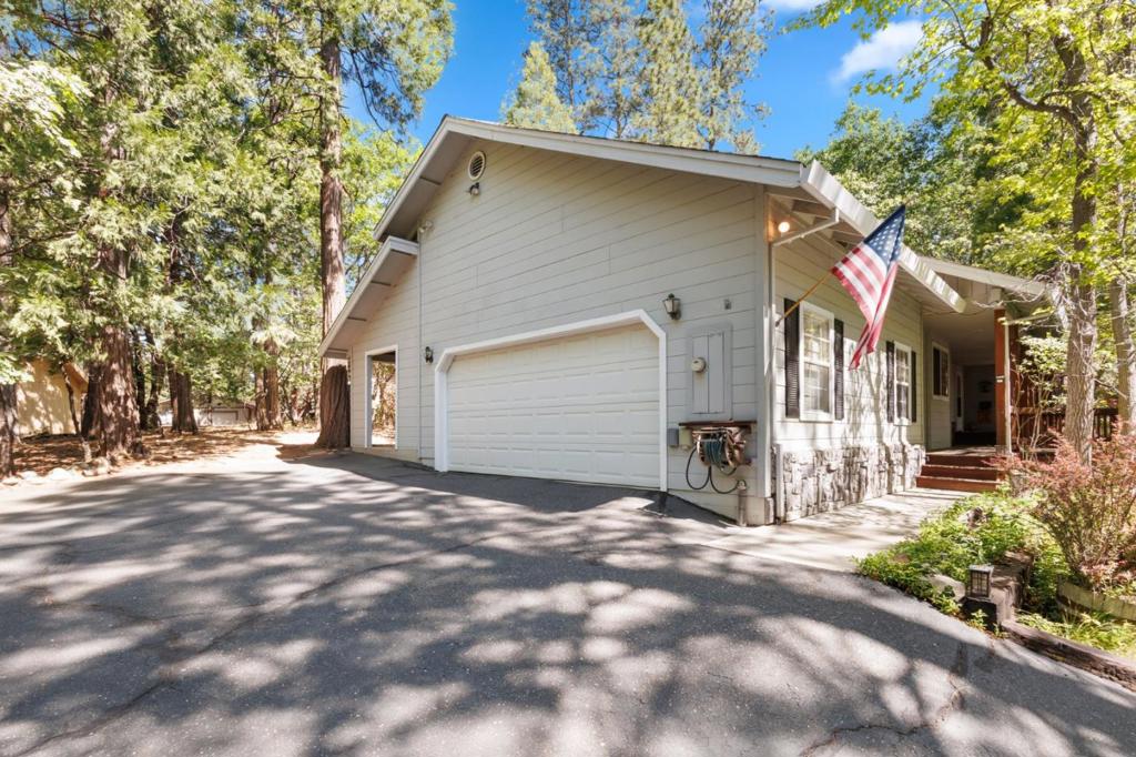 Escape to the charm of Cedar Ridge with this beautifully cared for single story mountain retreat, where comfort meets the beauty of the Sierra foothills. This home offers 3 bedrooms, 2 bathrooms (plus a urinal in the garage), and 1,780 sqft of living space on a generous 13,672 sqft lot. Inside, you'll find vaulted ceilings, five skylights that flood the home with natural light, and a bright, open layout where the kitchen overlooks the living room, perfect for both everyday living and entertaining. Large windows frame peaceful views of the surrounding greenery, letting in the fresh scent of mountain air. Step outside to the private deck, already wired for a jacuzzi, ideal for relaxing evenings. The primary suite features a cedar lined walk in closet and double sinks, while the attached two car garage adds convenience and function. Enjoy a short walk to a nearby water trail, and take advantage of exclusive private access to Dogwood Lake, perfect for summer days and quiet escapes. Whether you're looking for a weekend getaway or a full time home, this single level retreat offers the perfect blend of nature, light, and mountain charm.