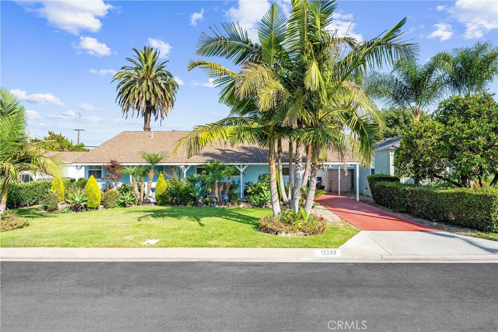 Your Downey Paradise Awaits!
This meticulously maintained 4-bedroom, 2-bath residence was recognized with the 2021 City of Downey Beautification Award. The property offers an inviting atmosphere and substantial potential for comfortable living.
The interior blends classic charm with modern updates, featuring both original and newer hardwood floors, Italian porcelain tile, and custom shutters throughout. All nine recently installed doors and upgraded dual-pane windows enhance energy efficiency. Lighting includes recessed fixtures and elegant crystal chandeliers. The spacious floor plan incorporates a marble-trimmed fireplace in the living room, a welcoming family room ideal for gatherings, and a dining area that transitions smoothly into a mid-century inspired kitchen. The kitchen is equipped with a newer cast iron double sink, a professional-grade faucet, Blue Pearl granite countertops, full backsplash, and a peninsula breakfast bar well-suited for daily meals or entertaining guests. Both bathrooms have been remodeled and include Kohler fixtures and designer lighting.
Additional living space is available in the permitted enclosed patio, which features wood-beam ceilings and a dedicated gas fireplace—an excellent option for use as a playroom, home office, or relaxation area.
The backyard offers an oversized, extra-deep pool surrounded by tropical landscaping, fruit trees, and a tiki hut with electricity, providing an optimal setting for outdoor entertainment and leisure.
For vehicle enthusiasts or those requiring extensive parking, the property delivers two long driveways—one front and one rear. The front driveway features a Porte Cochere with a professional hoist for engine work, two built-in compressor connections, and a 250-volt outlet. The detached 2.5-car garage provides ample storage and has a newer roof, while the back driveway accommodates RV parking or for additional entertainment.
Situated within a friendly Downey neighborhood near schools, shopping, dining, fitness centers, and other amenities, this residence presents an outstanding opportunity for convenient everyday living. This property is ready to become the foundation for memorable experiences.