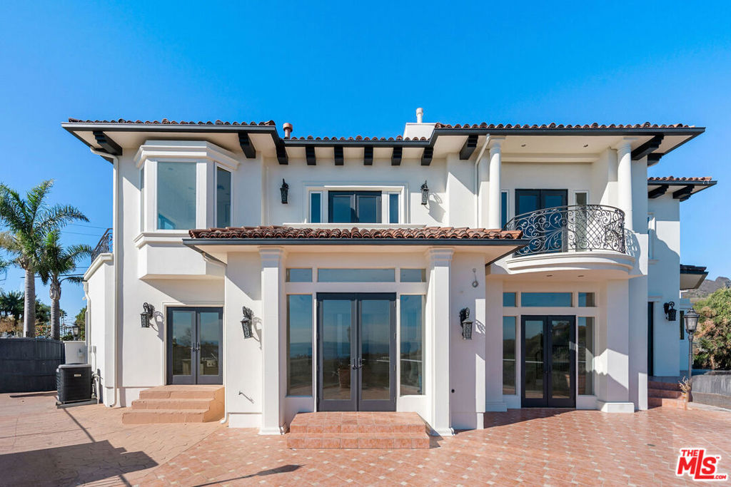This custom built Mediterranean estate situated on a private knoll overlooking sweeping unobstructed views of the ocean and mountains. Built in 2008, this estate is nearly 5200 square feet, meticulously crafted with the finest construction finishing and quality, undeniably marvelous. An extraordinary formal entry with spiraling staircase and grand ceilings welcomes you to the open layout. A beautifully scaled living room with fireplace. Across is a regal formal dining space beautifully appointed. A custom bar with sink and built in wine fridge open to the entertaining areas. Large family room with two sided fireplace that is shared with the living room. Views from every window and door will welcome the endless ocean views into every living space here. The custom kitchen is warm and stylish, custom cabinetry, stainless steel built ins, travertine flooring, beautiful granite counters. There is a junior primary on the main level with gracious accommodations and spectacular ocean views. An additional three bedroom suites on the second level including a magnificent primary suite with delightful scale and views of the ocean horizon. An alluring primary spa bathroom with double vanity, makeup desk, large soaking tub and two person shower all with custom stonework. An elegant walk in closet with spacious custom built ins. The outdoor deck is picturesque like a European ocean landscape and perfect for nightly enjoyment and pleasure. Distinctively located in prime Malibu at the corner of Kanan and PCH minutes from Country Mart and prime shopping and Malibu's finest amenities.