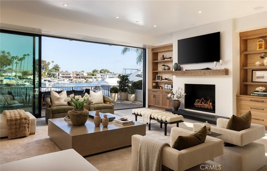 This exceptional waterfront custom home located in the Lido Village features unparalleled craftsmanship and luxurious designer finishes throughout. The Santa Barbara contemporary style sets the new standard for Newport waterfront luxury.  For the yachting and culinary enthusiast alike - mere steps from the front door are some of the best restaurants and nightlife in Newport, or venture to the backyard where the 75-foot dock awaits for ocean adventure.  The exterior is graced with white limestone and expansive Arcadia windows, framing picturesque water views from both the front and rear of the property.  

Spanning over 5,000 ft, every inch of this property is the epitome of attention to detail and master of craftsmanship.  With a push of a button, the Arcadia power slider doors usher in the bay breeze, seamlessly transforming the living room into true indoor/outdoor bayfront living. The living spaces boast stunning European oak herringbone and straight plank floors, with Venetian plaster walls and custom white oak beams adding warmth and texture.  The gourmet kitchen is a chef's dream, showcasing Cristallo Supreme slabs, hand-blown glass pendants, Wolf and Sub-Zero appliances, and a hand-plastered range hood. Custom white oak beams and cabinetry complete the sophisticated aesthetic, while the adjacent walk-in pantry features hand-painted marble backsplash for added flair. With Lutron lighting and integrated Sonos speaker system throughout the whole house, guests will always be greeted with the perfect combination of light and sound.

Each of the home's bathrooms exudes luxury, with handcrafted tiles, Waterworks burnished brass fixtures, and high-end TOTO washlets. The primary suite is a true sanctuary with custom white oak beams, and a Nero Lactea marble fireplace mantle, and custom his and hers walk-in closets imported from Italy that rival most designer showrooms. 

Additional standout features include a sophisticated office with handlaid ceiling wood paneling, a stunning staircase adorned with custom hand-painted Carrara marble tiles, and a wine cellar with semi-precious crystal quartz walls.  The garage is a showpiece in itself, with custom cabinetry, Caesarstone quartz counters, porcelain flooring, and room for 3 cars plus car lift. No expenses were spared during construction and design of this masterpiece - don't miss out on this rare opportunity to own bayfront elegance.