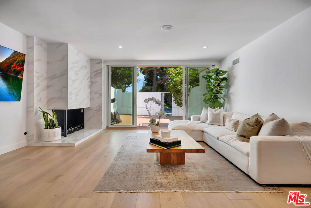 Welcome to this stunningly updated Brentwood Village townhome, where style meets comfort in one of Westside's most desirable communities. Designed for modern living, the light-filled living room flows seamlessly to a spacious private patio through sliding glass doors, perfect for entertaining or relaxing with effortless indoor-outdoor living. The chef's kitchen showcases stainless steel appliances, custom wood cabinetry, and elegant stone countertops. Additional features include rich hardwood floors, a sleek gas fireplace, recessed lighting, central HVAC, dual-pane windows, and a convenient downstairs powder room. Upstairs, the luxurious primary suite boasts a newly reimagined bathroom with a dual vanity, an expansive walk-in shower, and designer finishes. The secondary bedroom offers serene garden views and is paired with an updated bath featuring a stylish walk-in shower. A brand-new stacked washer and dryer, along with thoughtful upgrades throughout, add to the home's turnkey appeal. Nestled within a tranquil five-acre resort-style community, residents enjoy lush landscaped grounds, peaceful ponds, two sparkling pools, a spa, a dog park, picnic areas, and ample guest parking. All of this, just minutes from Brentwood's vibrant shops and restaurants, scenic parks, UCLA, and convenient access to the 405 Freeway.