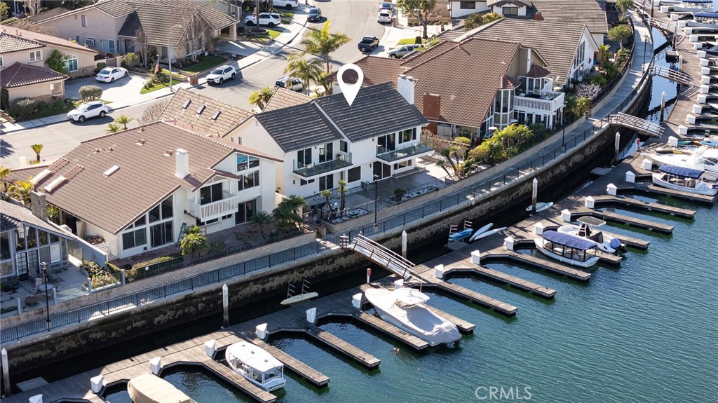 Live the ultimate Huntington Beach lifestyle in this waterfront Trinidad Island home with your own personal dock directly outside the back door. This beautiful Trinidad Island WATERFRONT Home is complete with a 180-degree view of the water, was recently remodeled, and is lovingly maintained! The Trinidad Island Lifestyle is amazing, featuring a beach, two playgrounds, large greenbelts, and waterfront path perfect enjoying the outdoors with your pets/friends, creating ample opportunities for an active lifestyle. Trinidad Island is one of the most wonderful neighborhoods in Coastal Orange County and is located within the award-winning Harbor View School District. The Gorgeous home is perfect for entertaining offering nearly 3,400 square feet of living space and a 3-car garage with additional space in the driveway. This gorgeous home is complete with an Open Concept floorplan including 4 spacious bedrooms, 3.5 bathrooms and has been beautifully maintained! The main level features a stunning front swinging door entry, large formal living room, formal dining perfect for entertaining, a bar, MAIN LEVEL BEDROOM AND FULL BATH + separate powder room, walk-in laundry room, and a light and bright kitchen open to the breakfast nook & family room. The gourmet kitchen features gorgeous countertops, a large pantry with a wine refrigerator and professional quality stainless steel appliances: built-in refrigerator, cooktop, microwave, oven, & dishwasher. Ascend the stairs to find a truly luxurious primary bedroom with full width waterfront views, retreat with fireplace, balcony, large walk-in closet, and spacious primary bath with private water closet, dual sinks, separate tub & shower. Meander down the hall to find two additional bedrooms, each with an adjoining balcony and a shared full-sized bathroom. Don’t forget to look at the bonus room adjacent to the secondary bedrooms. The expansive waterfront Entertainers back yard space includes a built-in BBQ and ample space for patio dining, with wonderful views of the water and other types of harbor activities such as boats, kayaks, & paddle boards passing by. The boat dock is ideal for your Duffy, fishing boat, or “Catalina Cruiser”. Live here and Elevate your Lifestyle with an opportunity to have a boat right at your back door within a fantastic neighborhood!