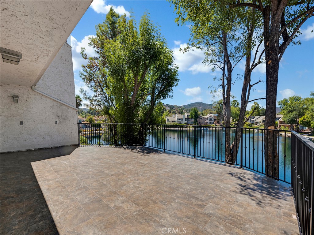Enjoy serene lake views from nearly every room in this tri-level home, featuring three lake-facing patios/decks plus a front balcony. A gated entry patio welcomes you inside. The main level offers a spacious kitchen overlooking the lake, a living room with fireplace, a generous family room, a breakfast/dining area, pantry storage, and a powder room. Upstairs, you’ll find two bedrooms with balcony access that share a Jack-and-Jill bathroom.
The lower level hosts an additional bedroom and bathroom, along with the primary suite—complete with a sitting area, updated bathroom, and walk-in closet. Both lower-level bedrooms open directly to a lakeside patio. This level also provides garage access and a laundry area. With direct lake access, you can enjoy the scenic lake trail, while being just minutes from Calabasas Tennis & Swim Center, The Commons, dining, and entertainment. All within the highly rated Calabasas school district.