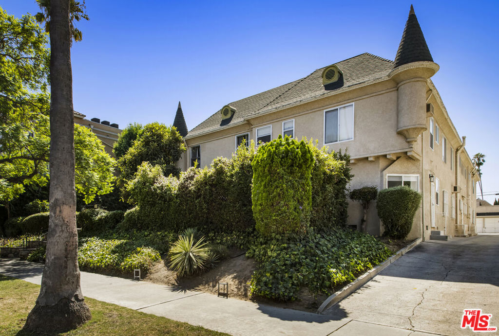 Enchanting 1930s French Normandy Condo - they just don't build them like this anymore! Tucked behind gates and set far back from the street, you'll arrive through a lush central courtyard with a front lawn, prolific lemon tree, and gorgeous shared outdoor dining area. Perfectly positioned at the rear of the complex, this oversized top-level one-bedroom feels both private and full of character. The gracious living room features warm bamboo floors, original crown molding, a freshly painted interior, and a large picture window overlooking the verdant courtyard. A separate dining room with built-in sideboard and a timeless pendant light flows seamlessly into the updated kitchen with granite counters, Shaker-style cabinetry, and stainless steel appliances. The sun-drenched spacious bedroom easily accommodates a king-size bed, while the beautifully tiled vintage bathroom remains period-appropriate with a separate tub and shower. Thoughtful updates throughout include fresh paint, new light fixtures, and central heat. Additional highlights include in-unit laundry room with extra storage, basement storage, private 1-car garage, and shared rooftop deck with downtown views. With easy access to DTLA and Koreatown, this condo is a truly timeless gem in the heart of the city.