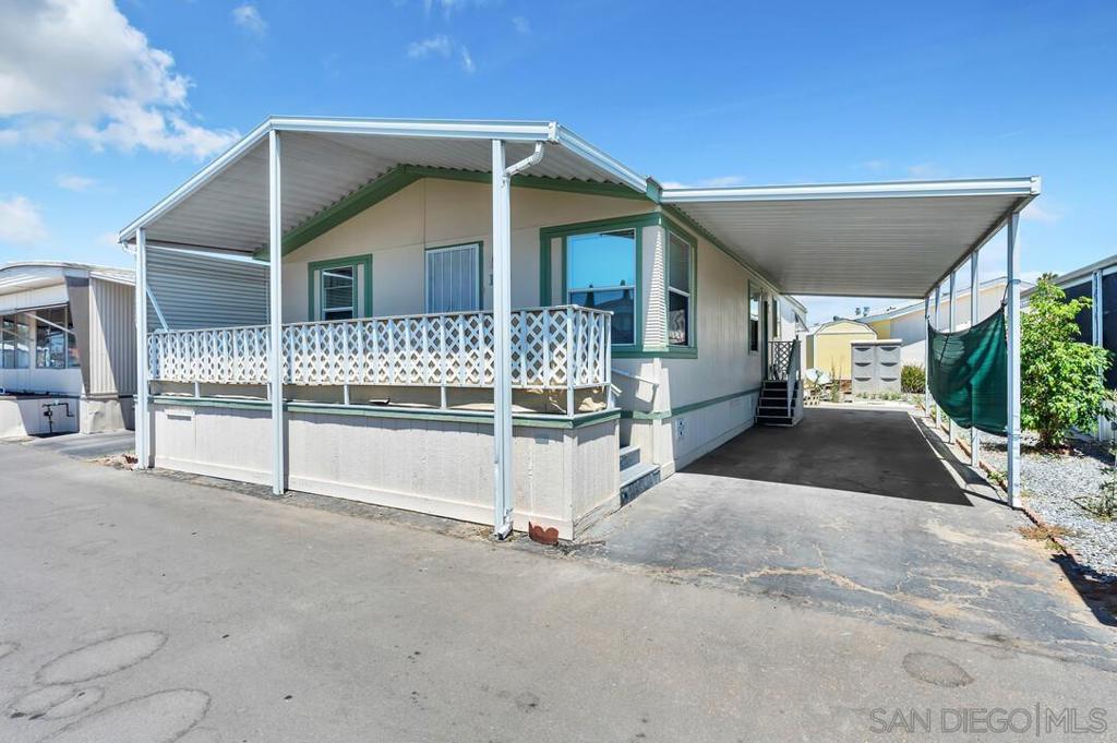 Welcome to this spacious and light-filled manufactured home located in the highly desirable El Cajon Valley Mobile Home Park, a well-maintained 55+ community in the heart of El Cajon. This inviting 2-bedroom, 2-bath home features vaulted ceilings and an open layout that creates an airy, comfortable atmosphere throughout. The generously sized kitchen is perfect for cooking and entertaining, complete with a large center island, ample counter space & abundant cabinetry. A versatile bonus room sits between the two bedrooms and can be used as a cozy family room or a formal dining area. The spacious primary suite boasts a walk-in closet and an oversized bathroom, while the second bedroom also offers comfort and privacy with a nearby full bath. A separate laundry room with washer and dryer adds convenience. Enjoy your morning coffee or evening breeze on the large, covered front porch. Additional features include a covered carport and low-maintenance landscaping. El Cajon Valley Mobile Home Park offers a welcoming lifestyle with fantastic amenities including a sparkling pool, card room, laundry facilities, and more. Plus, you’re just minutes from shopping centers, popular dining spots, and easy access to everyday essentials. Don’t miss this opportunity to own a beautiful home in a vibrant 55+ community!