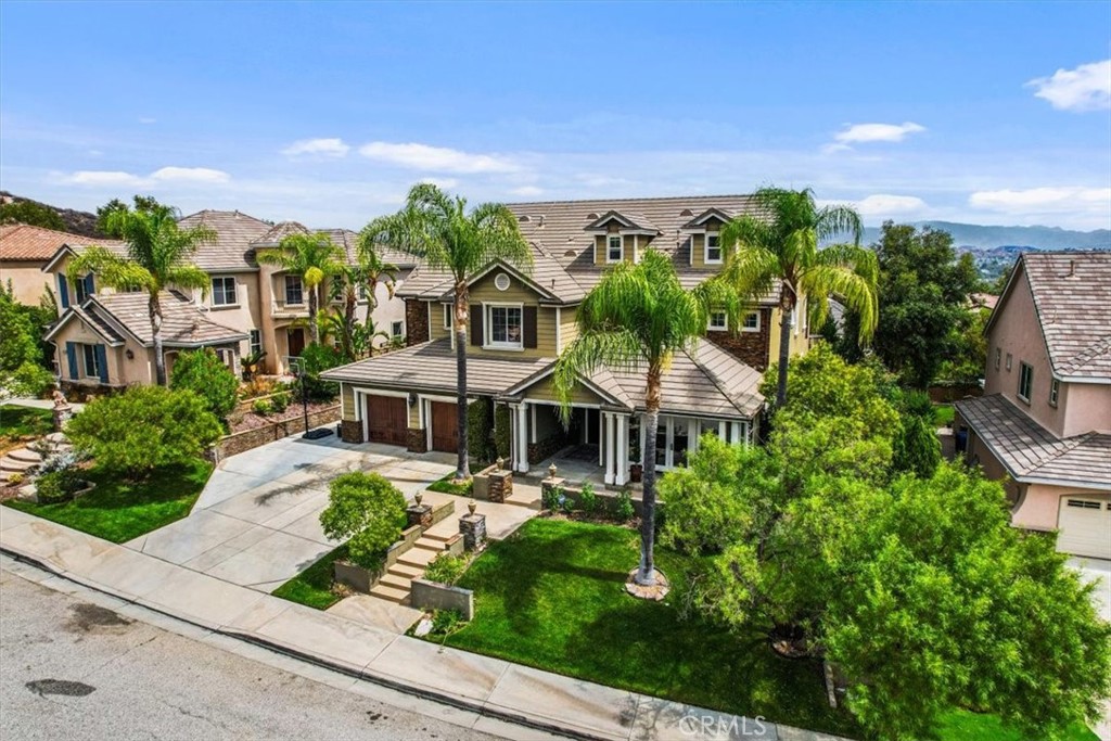 This magnificent home, located in Valencia’s prestigious Tesoro del Valle community, is a true showcase of luxury and craftsmanship. Built in 2004, this expansive single-family residence offers approximately 5,023 square feet of living space on a generous 8,462 sq ft lot, featuring 6 bedrooms and 6 bathrooms.
Step inside to discover an atmosphere of elegance, highlighted by soaring ceilings, refined crown molding, and rich hardwood flooring that create a warm and inviting ambiance. The formal living room, accented by French doors that open to the front patio, flows seamlessly into a grand dining area—perfect for entertaining.
At the heart of the home lies a gourmet kitchen, equipped with a custom tile backsplash, stainless steel appliances, a Sub-Zero refrigerator, Thermador microwave, GE Monogram stove, GE Profile double ovens, and a wine cooler. The kitchen opens to a bright breakfast nook and cozy den overlooking the backyard oasis.
A convenient first-floor en-suite bedroom provides comfort and privacy for guests, complemented by a nearby powder room. Upstairs, four additional bedrooms include a luxurious primary suite with its own balcony offering scenic views, a spacious walk-in closet, dual vanities, solid marble slab shower walls, and a soaking tub. Two bedrooms share a Jack-and-Jill bathroom, while another features its own private bath.
On the third level, a private suite includes a full bath and walk-in closet—ideal as a sixth bedroom, home office, theater, or playroom, offering exceptional versatility.
The backyard retreat is designed for both relaxation and entertaining, featuring a sparkling pool, lush landscaping, and serene views. Additional highlights include a spacious 4-car garage, owned Tesla solar system, Tesla charger, whole-house water filtration and softener, and a gas-powered generator.
Residents of Tesoro del Valle enjoy access to premium amenities, including a clubhouse, community pool, lake, sports fields, playgrounds, and more.