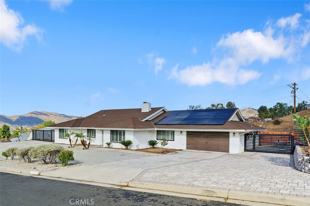 Don’t miss this rare opportunity to own a beautifully upgraded pool home in one of Moreno Valley’s most desirable neighborhoods! Perfectly situated on half acre lot, this stunning single-story residence combines comfort, convenience, and incredible city and mountain views. The main home features 4 spacious bedrooms and 3 bathrooms with a versatile layout that includes two primary suites ideal for multi-generational living or guest accommodations. The open-concept design showcases gorgeous vinyl flooring, double-pane windows with white shutters, and a double-sided fireplace in the main living room and the formal living area. The modern kitchen is a chef’s dream, complete with a center island gas cooktop, double wall ovens, ample cabinetry, and a walk-in pantry. Step outside to an entertainer’s paradise! The expansive backyard features a sparkling Pebble Tec pool and spa with LED lighting, an energy-efficient pump system, and direct bathroom access—perfect for summer gatherings. The artificial turf is low maintenance and there is plenty of room at the rear of the property to bring your imagination - pump track, basketball court, cabana with built in BBQ, etc; it's your dream backyard! The property also offers RV parking and a 1 bed/ 1 bath ADU, providing flexible space for guests, a home office, or rental income. Additional upgrades include remodeled bathrooms, solar panels for energy efficiency and cost savings, a 5-ton A/C and heating unit, a water softener system, stylish front pavers, and modern side gates. Located close to shopping, dining, and outdoor recreation, this turn-key home offers the best of Southern California living with exceptional views and upgrades throughout.