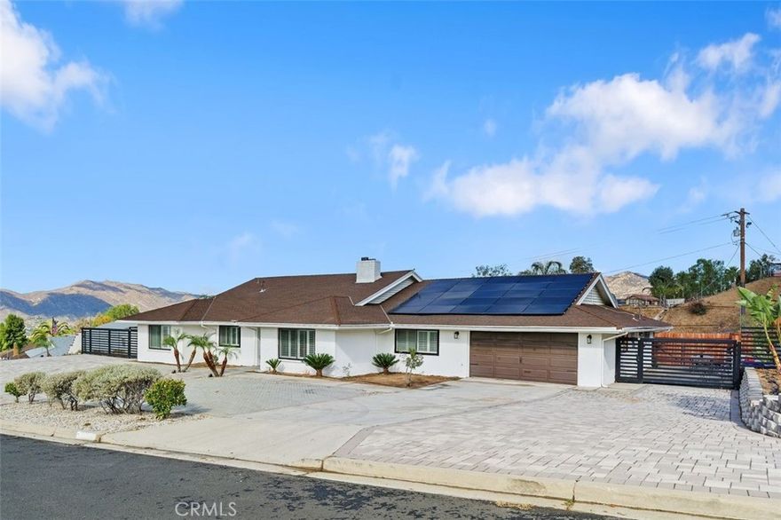 Don’t miss this rare opportunity to own a beautifully upgraded pool home in one of Moreno Valley’s most desirable neighborhoods! Perfectly situated on half acre lot, this stunning single-story residence combines comfort, convenience, and incredible city and mountain views. The main home features 4 spacious bedrooms and 3 bathrooms with a versatile layout that includes two primary suites ideal for multi-generational living or guest accommodations. The open-concept design showcases gorgeous vinyl flooring, double-pane windows with white shutters, and a double-sided fireplace in the main living room and the formal living area. The modern kitchen is a chef’s dream, complete with a center island gas cooktop, double wall ovens, ample cabinetry, and a walk-in pantry. Step outside to an entertainer’s paradise! The expansive backyard features a sparkling Pebble Tec pool and spa with LED lighting, an energy-efficient pump system, and direct bathroom access—perfect for summer gatherings. The artificial turf is low maintenance and there is plenty of room at the rear of the property to bring your imagination - pump track, basketball court, cabana with built in BBQ, etc; it's your dream backyard!  The property also offers RV parking and a 1 bed/ 1 bath ADU, providing flexible space for guests, a home office, or rental income. Additional upgrades include remodeled bathrooms, solar panels for energy efficiency and cost savings, a 5-ton A/C and heating unit, a water softener system, stylish front pavers, and modern side gates. Located close to shopping, dining, and outdoor recreation, this turn-key home offers the best of Southern California living with exceptional views and upgrades throughout.