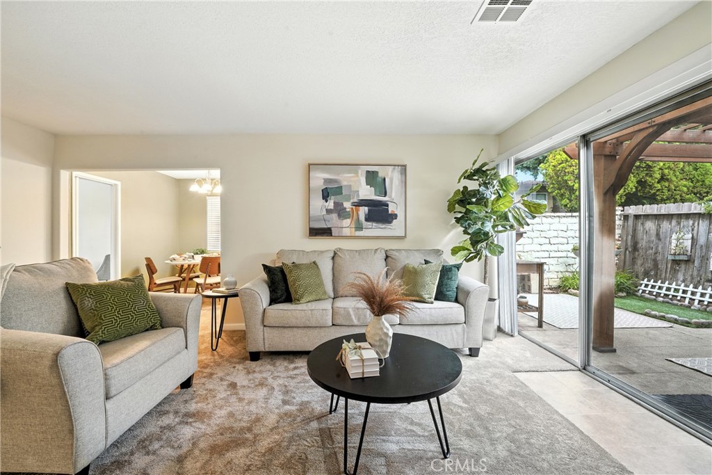 Welcome to this inviting 3-bedroom, 2-bathroom condo offering 1,334 square feet of well-designed living space in the heart of Orange. Nestled in a beautifully maintained community, this spacious unit delivers the perfect combination of comfort, convenience, and value. Step into an open-concept layout featuring a generous living room filled with natural light, tile, carpet flooring and a private back yard. Perfect for relaxing or entertaining. The updated kitchen laminate countertops, a breakfast bar, and plenty of storage space, seamlessly flowing into the dining area. The oversized primary suite includes a walk-in closet and an end-suite bathroom, while two additional bedrooms provide flexible space for guests, a home office Community amenities include a sparkling pool, laundry facilities, and lush greenbelts—all just minutes from Old Towne Orange, Chapman University, shopping centers, dining, and major freeways (55, 22, and 91). Don't miss this rare opportunity!