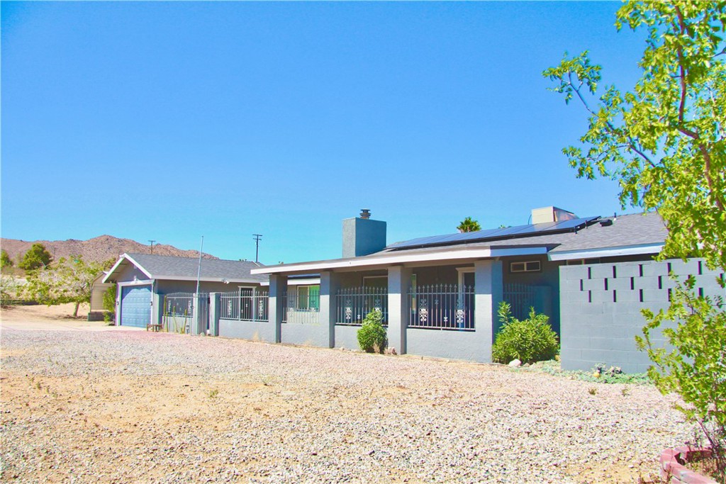 This meticulously updated property in Joshua Tree offers the perfect blend of modern luxury and natural beauty, making it an ideal primary residence, vacation home, or short-term rental investment. Step inside this 3-bedroom, 2-bathroom home and discover a sanctuary designed for comfort and relaxation. The fully renovated kitchen boasts quartz countertops, stainless steel appliances, and even two TVs built into the backsplash so you can enjoy your favorite shows while you cook. The large island flows seamlessly into the bright and spacious living area, complete with recessed lighting, a cozy fireplace, and expansive windows that frame the stunning desert landscape. For entertainment, there's even a fun karaoke corner. Each bedroom provides a peaceful escape with cooling fans and hardwood floors. The converted garage offers a dedicated playroom for kids, ensuring peace and quiet for everyone. Explore the indoor 3D tour to truly experience this dream setting. Situated on a spacious corner lot, the expansive outdoor space is an entertainer's dream. Enjoy the desert sun by the pool and spa, gather around the outdoor fire pit, or host dinner parties on the covered patio. The fully secure and fenced backyard provides peace of mind. This home also features energy-efficient systems, solar panels and an EV charger, adding to its modern appeal. Plus, it's just minutes from Joshua Tree National Park. With its full renovation, desirable location, and excellent revenue potential, this property is a truly remarkable investment. Don't miss this opportunity to own this turnkey desert oasis.