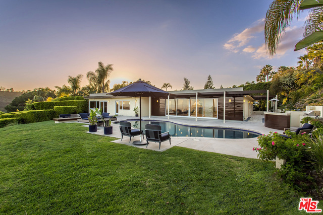 Situated behind private gates on a promontory with explosive, unobstructed city and coastline views. Completely remodeled, this beautiful and bright home features Fleetwood sliding walls of glass that open to a vast terrace ideal for entertaining, outdoor dining with barbecue, and spectacular pool and spa. Greeted by the beautiful foyer, the open floor plan leads into the spacious living room, open dining room with pass-through fireplace, gourmet kitchen with center island, skylight, and den with wet bar. Enjoy sparkling city views from the lavish master suite with a fireplace, a spa-like bath and large walk-in closet. Additionally, two guest bedrooms w/ en suite baths, plus a tremendous theater room with impressive surround sound, and a large home office. Just minutes to shops and fine dining in Beverly Hills.