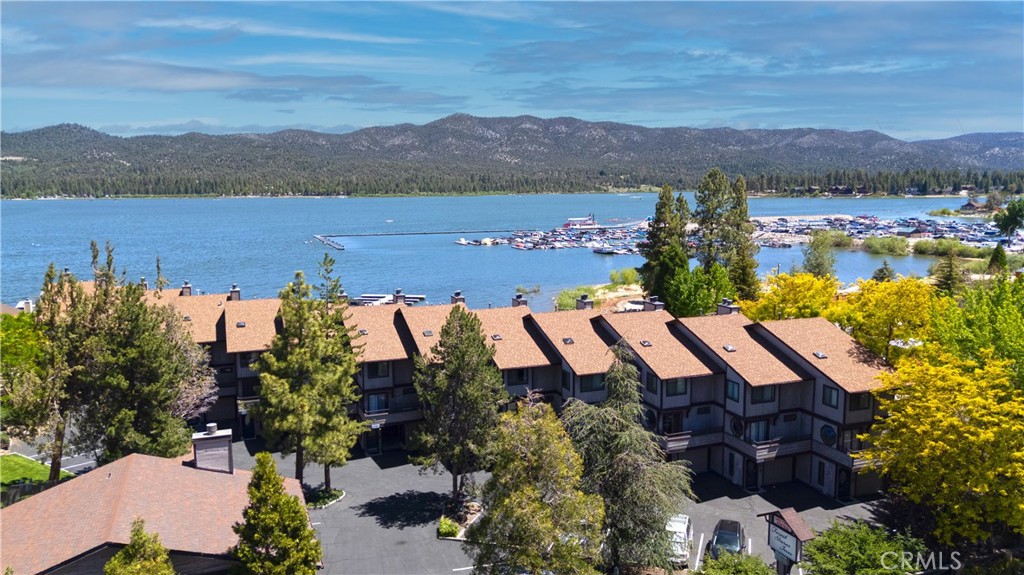 Big Bear Lakefront Luxury Condo with Dock Slip, Studio Suite & Prime Village Location! This beautifully upgraded 3-bedroom, 4-bathroom tri-level condo offers the ideal blend of luxury, flexibility, and unbeatable location—situated right on the shores of Big Bear Lake and just a short stroll to the Village. Located in the exclusive Forest Shores community of only 13 units, this unique residence quietly distinguishes itself with beautiful upgrades and is especially appealing to those seeking a luxury turnkey experience. The property includes a boat slip, attached garage, and access to amenities including a pool, spa, and private storage area. Inside, you’ll find quality upgraded finishes throughout: granite countertops, soft-close cabinetry, stainless appliances, and a blend of wood, carpet and marble tile flooring. The spacious and open lake view living area features custom fireplace, upgraded kitchen, dining area and convenient bathroom. This level also includes a lakefront deck with wide-open lake views. The upper level has the inviting primary suite boasting vaulted ceilings, skylights, spa tub, heated bathroom flooring and its own private balcony with unobstructed, panoramic lake views. There is also a second guest bedroom with adjacent full bath on this level. Don't miss the finished attic bonus room which could be a 4th bedroom. The lower level is a separate studio suite with custom stone fireplace, kitchenette, full bathroom with heated flooring, and its own separate patio entrance right on the lakeside—perfect as a guest suite or income-generating rental. You'll have a front-row seat to watch the annual 4th of July fireworks! Short walk to restaurants, shops, and marina plus a quick drive to ski resorts. This is Big Bear lakefront living at its best—whether as a personal escape or an income generating rental. Don't miss your opportunity to own this well located four season resort property!