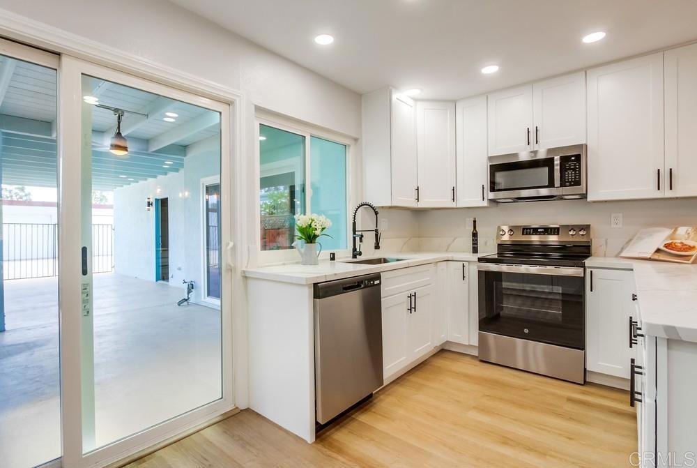 Step into this fully renovated home offering modern finishes and thoughtful upgrades throughout. Unlike many in the community, this unit features both a garage and carport, providing ample parking and extra storage. Enjoy the privacy of an end unit, with a welcoming front entry surrounded by a well-kept grassy area. The primary bedroom includes its own patio, perfect for relaxing in the cool coastal breeze, and a convenient half bath for added comfort. Move-in ready and designed for easy living in one of Oceanside’s most sought-after 55+ communities!