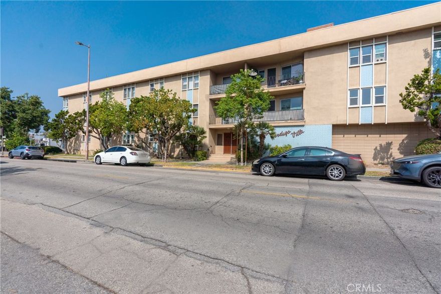 Discover this charming and well-maintained condo located just moments from The Americana at Brand, Glendale Galleria, Glendale Fashion Center, and Central Park Paseo. Inside, you’ll find elegant base and crown moldings, stunning flooring, and large windows that fill the home with natural light. The bright and spacious living room features a decorative fireplace and opens to a private balcony with a lovely view.

The kitchen offers rich wooden cabinetry, ample counter space, and durable tile flooring. Both bedrooms are generously sized and include plenty of closet space. Community amenities include assigned parking, a serene courtyard, and a BBQ area with lounge seating. (Accurate HOA price will be updated on a later date.)