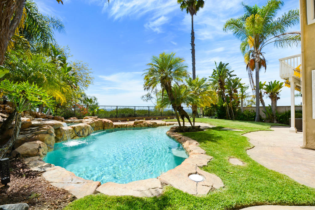 Experience resort living every day in this stunning 5-bedroom executive lifestyle home at the peak of coveted Pacific Hills. The backyard is a true private oasis complete with swaying palm trees, lush landscaping, a pebble-bottom saltwater pool with zero-entry design, cascading waterfall, and spa. No rear neighbors and expansive hillside views make this retreat feel like a world-class resort right at home. Inside, the grand double-door entry opens to soaring ceilings, travertine floors, hardwood living areas, and an open-concept family room with fireplace. The gourmet kitchen features a large island with pendant lighting, new GE Profile microwave, new dishwasher, and a walk-in pantry perfect for entertaining and everyday luxury. Upstairs, enjoy a primary suite with balcony offering peek-a-boo views of Dana Point Harbor, plus additional bedrooms including another balcony retreat. Lease includes professional landscaping, pool maintenance, and Lake Mission Viejo access with boating, concerts, and private beaches. Energy-efficient with paid solar. This home blends executive elegance with resort-style living a rare offering in Mission Viejo's premier neighborhood.