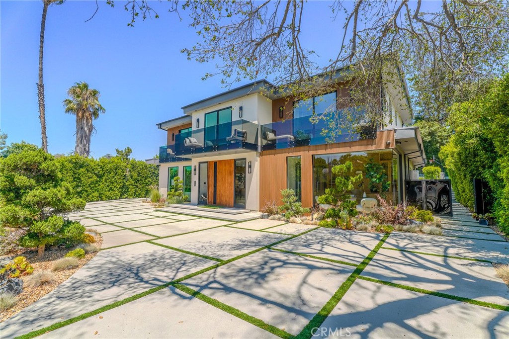 Incredible Private Estate located in one of the most sought-after neighborhoods in Tarzana, South of the Boulevard! This stunning, gated estate seamlessly blends modern design with luxurious living. Surrounded by meticulously landscaped grounds, the residence offers 5 bedrooms, 7 bathrooms, a study, a media room, and an array of high-end amenities perfect for both relaxation and entertaining. The open-concept floor plan ensures a smooth flow between living spaces, ideal for hosting everything from intimate gatherings to large-scale events. The chef’s kitchen is a culinary haven, featuring premium Wolf and Sub-Zero appliances, a spacious center island, high-end countertops, ample cabinet storage, walk-in pantry, and a built-in Miele coffee maker. The serene primary suite offers a private retreat with a cozy fireplace, a spa-inspired bathroom, an expansive walk-in closet, and two private balconies. Additional highlights include 6 fireplaces throughout the home, a Crestron smart home system, Fleetwood pocket doors, integrated indoor/outdoor speakers, and top-tier security features with cameras. Outdoors, the estate is equally stunning, with lush gardens, a reverse infinity pool and spa, a pool house (with bathroom), and a fully equipped outdoor kitchen with a 5-burner stove, BBQ, and beverage fridge. The covered patio has dual fireplaces that creates a perfect space for year-round enjoyment. For active lifestyles, the property includes a lighted sport court with basketball hoop and putting green, offering plenty of options for recreation. The detached garage accommodates luxury vehicles, parking for tour buses/RVs, with additional onsite parking for 10+ cars. Solar panels and underground utilities promote sustainability, enhancing the estate's eco-friendly appeal. Offering unmatched privacy, comfort, and sophistication, this estate is the ultimate sanctuary for those seeking an unparalleled Southern California living experience.