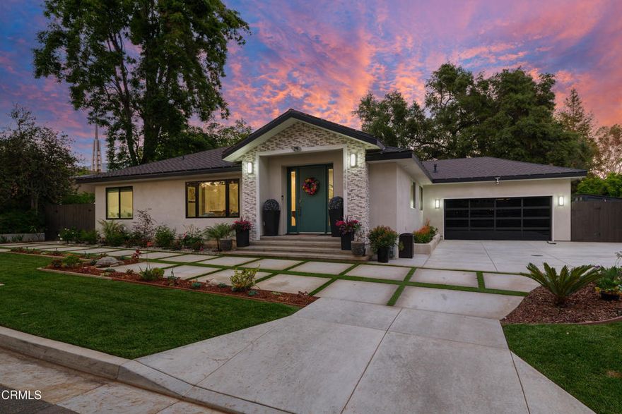 Enter into contemporary luxury in this spectacular, fully reimagined residence. Situated on a beautifully landscaped lot, this architectural masterpiece offers seamless indoor-outdoor living, exquisite custom finishes & a detached 1-bedroom guest house. Upon arrival, striking curb appeal hints at the sophistication within. Through the front entry, wide plank wood-like flooring flows throughout, complemented by soaring vaulted ceilings, custom multilayer tray ceilings & recessed lighting. The formal living room is anchored by a sleek, custom-tiled electric fireplace & framed by a large picture window that floods the space with natural light. A stylish partition separates the living & dining areas, enhancing the flow without sacrificing definition. An office with recessed lighting is tucked just off the main living area. The open family room features triple-panel sliding glass doors that open fully to the deck & backyard, creating a true indoor-outdoor experience. The kitchen is a chef's dream with an oversized island, quartz countertops, soft-close cabinetry, custom subway tile backsplash & a full suite of stainless steel appliances. A large walk-in pantry & a designer half bath complete the kitchen area. A full laundry room with utility sink leads to the finished 2-car garage with attic storage & pass-through access to the backyard. An additional flex room near the garage is perfect for a 2nd office or gym. The private quarters include 4 spacious bedrooms & 3 bathrooms. The primary suite is a retreat, accessed through French doors & featuring vaulted ceilings & dual walk-in closets. The spa-inspired ensuite bathroom offers dual vanities, a jetted soaking tub, & a custom walk-in shower. Additional bedrooms each feature recessed lighting & mirrored closets, while the secondary bathrooms showcase high-end tile work & quartz vanities. Completing the estate is a beautifully appointed 1-bedroom, 1-bath ADU. Featuring its own private entrance, this guest house offers wide plank wood-like flooring, recessed lighting, crown molding, a dining nook & a full kitchen with quartz countertops & a 4-burner gas range. The bathroom includes a walk-in shower with bench seating. Also here, hookups for a stackable washer & dryer. Outdoor amenities include multiple seating & entertaining areas, a putting green shaded by sail shades & a backyard designed for relaxation & fun. This turnkey residence delivers impeccable design & unparalleled comfort in every square foot.