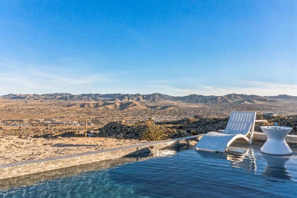 Rare Hilltop Oasis in Western Hills Estates, Yucca Valley - Panoramic Views on 1.22 hilltop Acres, 4 Bedrooms 2 Bathrooms with new pebble-tec pool and there is an in-ground spa, perfect for stargazing or relaxing after a day in the desert. Nestled at the end of a quiet cul-de-sac and perched high above Yucca Valley, this rare hilltop retreat offers unparalleled panoramic views stretching from the heart of town all the way to the majestic Joshua Tree National Park. Recently received new exterior paint as well. This home offers expansive windows and outdoor living spaces that capture the breathtaking desert scenery and magical vibe that only the Joshua Tree area can offer. This magical property provides tranquility and privacy, while remaining just minutes from top attractions: Pappy & Harriet's in Pioneertown,Joshua Tree National Park just about 15 min away, Palm Springs 30 min and Big Bear Lake 1hr 15min. Whether you're seeking a full-time residence or a weekend getaway, this hilltop gem offers unmatched lifestyle potential in a truly one-of-a-kind setting. Don't miss your chance to own a piece of the high desert dream. All information is deemed reliable, however, buyer should conduct their own inspections and due diligence to all information stated.