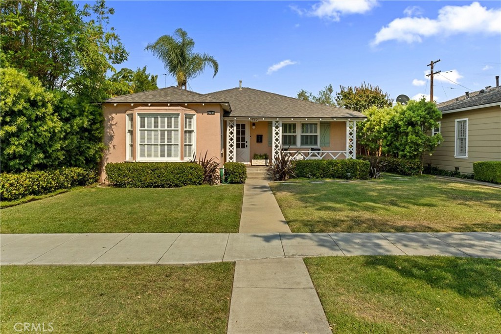 Nestled in the highly sought-after California Heights neighborhood, this beautifully maintained residence effortlessly blends timeless character with contemporary upgrades! Upon entry, hardwood floors and arched doorways set a warm and inviting tone, leading into an expansive living room featuring a bay window and decorative elegant fireplace. Just beyond, a formal dining room crowned with a classic chandelier flows seamlessly into a nostalgic yet functional kitchen showcasing iconic 1950s black-and-white checkered tile flooring, a retro-style refrigerator, and vintage pendant lighting. These period details are perfectly complemented by sleek soapstone countertops, marrying charm with modern utility. This spacious home also features two bedrooms and a large bathroom that has both a walk-in shower and a large tub to relax and unwind. Out back you will find manicured greenery as well as a large covered patio to gather with loved ones and create memories all year long! Additional highlights include custom window coverings, recessed lighting, central AC and an abundance of storage! Finally, the two-car detached garage has direct alley access providing amazing ADU potential. Conveniently located near the shops and restaurants of Bixby Knolls and LBX, with easy access to local golf courses and the Long Beach Airport, this delightful home offers a lifestyle of comfort, charm, and convenience—ready to be enjoyed!