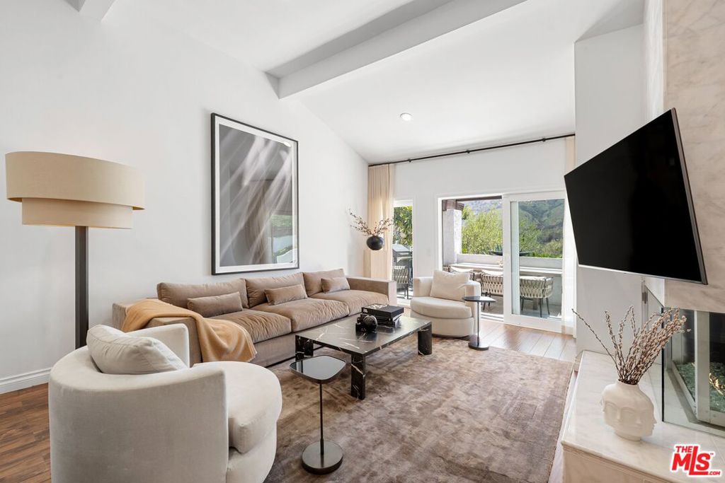 Step into luxury and serenity in this exquisitely remodeled Mountain View townhouse, nestled in the peaceful Palisades Highlands. Bathed in natural light and surrounded by sweeping mountain vistas, this sophisticated home offers a seamless blend of high-end finishes and tranquil living. The living room stuns with a floor-to-ceiling enclosed fireplace wrapped in custom Carrara marble, setting the tone for refined comfort. The chef's kitchen is a work of art, featuring custom cabinetry, Cambria Quartz extra-thick countertops, a Kohler farm-style sink with a hands-free faucet, and a full suite of new stainless appliances including a range, vent hood, dishwasher, and microwave. A generous pantry cabinet and sleek layout make the space as functional as it is beautiful. The custom staircase is a showstopper, framed by a tempered, shatter-resistant glass banister and illuminated by an 8-foot raindrop chandelier featuring partial Swarovski crystals adding a dramatic yet elegant focal point. Upstairs, the primary suite offers a peaceful retreat with a custom 7-foot-tall built-in closet and a spa-inspired bath wrapped in Carrara marble on both floors and walls, complete with a custom glass shower enclosure, Kohler fixtures, and Fortis trim -- leading to an additional primary closet. All bathrooms in the home have been remodeled with premium materials and thoughtful design. Additional highlights include water- and scratch-resistant AquaGuard flooring, upgraded LED lighting, a new electrical panel and water heater, and all new dual-pane sliding doors and windows ensuring both comfort and efficiency. Enjoy access to the Highlands' serene lifestyle, including a community pool and spa. HOA dues include water and earthquake insurance. This is more than just a home it's a peaceful mountain-view sanctuary.