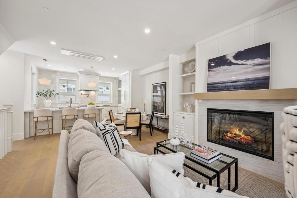 Live the Coronado lifestyle in this stunning newly built coastal retreat, meticulously designed for seamless everyday living and sophisticated entertaining. This 3-bedroom, 3.5-bath residence features a spacious open-concept floor plan that flows effortlessly from indoor comfort to outdoor charm. Relax on the inviting front porch beside the cozy outdoor fireplace, or ascend to the expansive rooftop deck to savor panoramic views—perfect for sunset cocktails, weekend gatherings, or quiet moments under the stars. Inside, timeless elegance meets modern functionality with warm neutral tones, exquisite quartzite countertops, and top-of-the-line Bosch appliances. Every custom bathroom is adorned with refined gold accents, adding a tasteful touch of luxury throughout. Thoughtfully equipped for today and tomorrow, the home includes installed solar panels for energy efficiency and is pre-wired for a future elevator—blending sustainability with long-term versatility. From its coastal charm to its elevated finishes, this home offers a rare opportunity to enjoy island living at its finest.