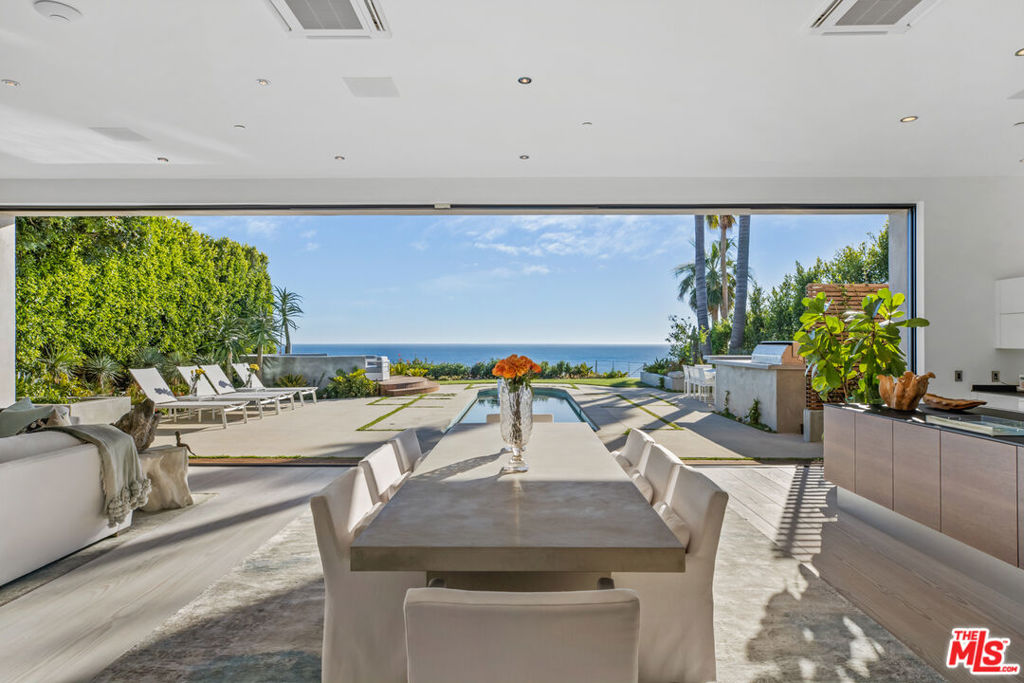Paradise found on the Encinal bluffs. Experience breathtaking, panoramic ocean and whitewater views from Catalina to the Channel Islands at this exceptional oceanfront retreat on approximately .65 acres on Malibu's ultra desirable Encinal Bluffs. This estate is a masterclass in relaxed coastal luxury, singularly beautiful, exquisitely appointed, and designed to capture year round sunsets in their full cinematic glory. Tucked behind dual gates for maximum privacy, this hi-tech contemporary residence welcomes you with beautifully curated landscaping and soaring ocean views from nearly every room. At the heart of the home, a 36-foot motorized wall of glass seamlessly transforms the expansive living, dining, and kitchen area into a stunning oceanfront resort, featuring a pool with Baja shelf and spa, outdoor bar/kitchen, al fresco dining area, a large circular firepit lounge, all tailored for memorable moments and effortless hospitality. Each evening, the horizon becomes a living canvas of fiery golds, soft purples, and deep blues washing over the ocean in an intimate and infinite sunset show. A second, more secluded firepit rests atop the bluff, where a private path leads down to your own sandy cove, complete with Adirondack chairs and lush, flowering greenery. Inside, a light-filled open floor plan blurs the line between indoor and outdoor living. European wide-plank wood flooring and soaring ceilings create an airy, expansive atmosphere. The great room is anchored by a dramatic fireplace set in back-lit Brazilian marble, flanked by a built-in humidor and a temperature-controlled wine closet, custom crafted for seamless entertaining. The sleek chef's kitchen inspires culinary creativity with touch-open European cabinetry, Gaggenau appliances including steam and wall ovens, and a built-in coffee system. A cozy media room, showcasing a fur covered couch, can be tucked away for added privacy by a stylish, sliding barn door. A full bath and laundry room complete the main level. From the dramatic double height entry hall, floating stairs ascend to a spacious upper landing with a sitting area. Three well-appointed bedrooms await each featuring automated window shades, private deck access and an ensuite bath for effortless comfort and privacy. The ocean and pool view primary suite is a refined retreat, featuring dual closets and a spa-inspired bath with a glass-encased ocean facing rain shower, designed for indulgence. Additional features include garage, guest parking, an outdoor shower, integrated solar power, and a suite of smart home amenities including security and sound systems. With its blufftop setting and striking design, this contemporary estate takes the Malibu lifestyle to new heights. The majority of the furniture excluding all art, crystals, decorative items and personal effects are included in the sale of the property. See agent for additional exclusions.
