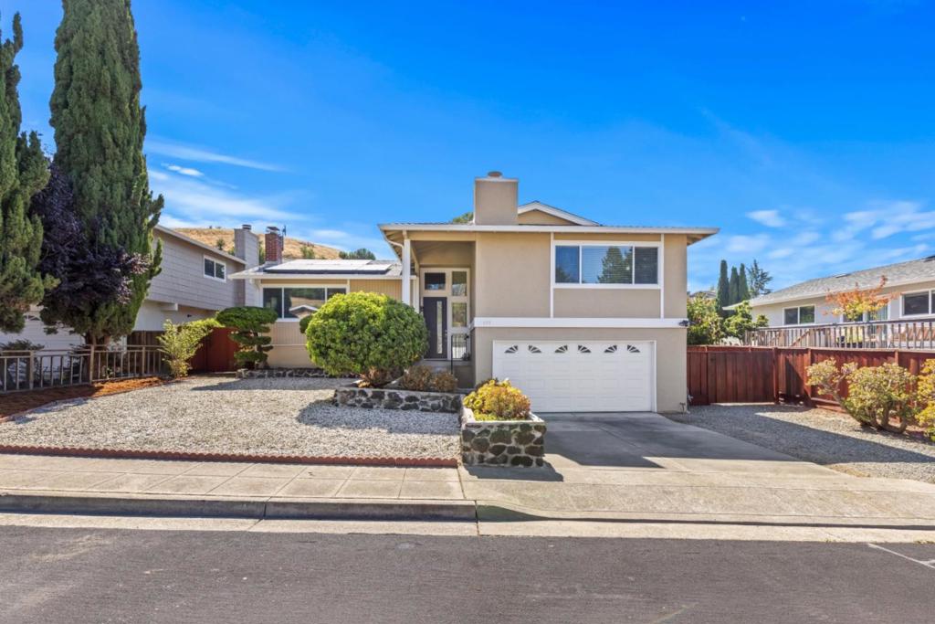 Welcome to this stunning home offering 4 bedrooms and 2 full bathrooms with 1,836 sq ft of thoughtfully designed living space. A beautifully updated chef's kitchen with sleek quartz countertops and walk-in pantry is perfect for culinary enthusiasts. High ceilings add to the homes airy and open feel with abundant natural light gleaming through double pane windows. Featuring updated bathrooms and spacious primary en-suite with fire place designed for comfort and relaxation. Generous sized bedrooms with bonus room on lower level with updated half bath. Enjoy year-round ease with central Air Conditioning and ceiling fans, or cozy up by the fireplaces on cool evenings. The flooring blends carpet, LVP and tile, creating a stylish interior. Step outside to a spacious private low maintenance backyard, perfect for entertaining, gardening or simply relaxing. From the upper deck, take in amazing sweeping views of city and rolling hills that make this home truly special. Additional features include a laundry area in the garage with washer/dryer included, leased solar, storage galore, rainwater storage barrels and shed. Close to Bart, shopping, parks. This home beautifully combines comfort, charm, and functionality ready to welcome its next owners! Come experience this gem.