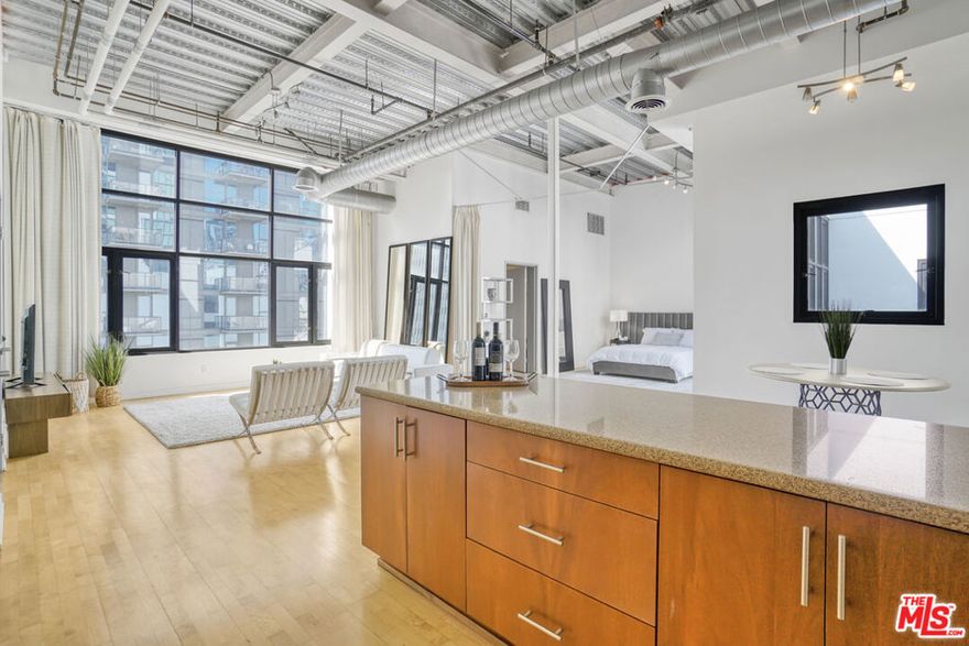 Stunning Penthouse Live/Work Loft at Grand Ave Lofts. Experience the perfect blend of style, comfort, and convenience in this dramatic penthouse in Downtown Los Angeles South Park. With soaring 15-foot ceilings and expansive windows, this residence is bathed in natural light throughout the day, creating an open and inviting atmosphere. The spacious floor plan features a modern kitchen with stainless steel appliances, sleek cabinetry, and ample counter space perfect for cooking and entertaining. For added convenience, a washer and dryer are located inside the unit, while two oversized walk-in closets provide abundant storage. This rare offering also includes two side-by-side parking spaces, ensuring hassle-free access in the heart of the city. As a resident, you'll also enjoy access to the full suite of luxury amenities in the neighboring building, including a resort-style swimming pool, a state-of-the-art fitness center, sand volleyball court, basketball court, business center, and so much more. Located in the vibrant South Park neighborhood, the Grand Ave Lofts put you just blocks away from LA Live, Whole Foods, world-class dining, shopping, and entertainment. Whether you're looking for a stylish urban retreat, a flexible live/work setup, or a home with unbeatable amenities, this penthouse loft offers it all.