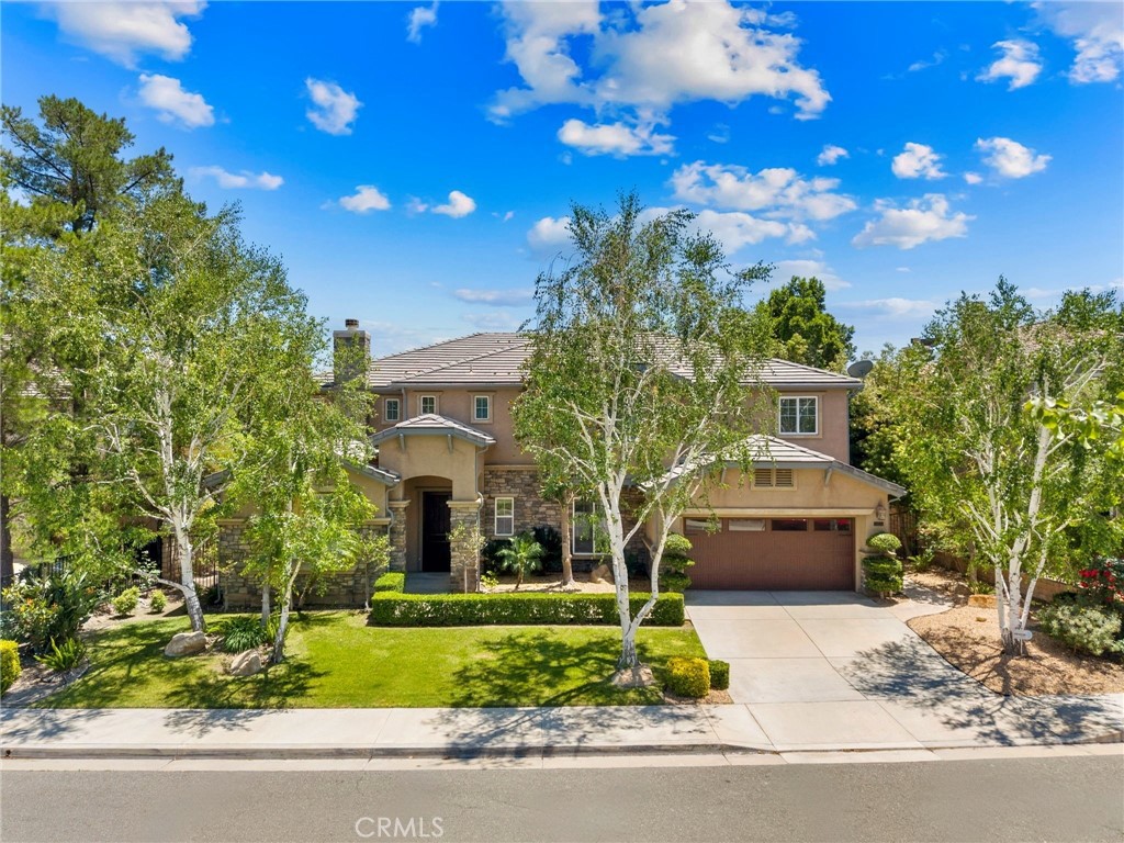 NEW PRICE!! Welcome to this exceptional Executive POOL Home, perfectly situated at the top of the Tesoro Del Valle neighborhood with sweeping panoramic VIEWS. Spanning nearly 5,000 square feet, this expansive residence offers five bedrooms, five bathrooms, formal living and dining areas, a large family room, generous loft, and a private home theater. Upon entry, you’re welcomed by soaring ceilings, brand new 10-inch wide plank wood flooring in warm Sahara tones, imported Italian tile with granite inlays, custom millwork, and a dramatic spiral staircase. The home boasts four fireplaces and beautifully designed interior finishes that create a refined and inviting atmosphere. Nearly every room captures stunning views of the Santa Clarita Valley. The chef’s kitchen is thoughtfully designed with premium stainless steel Monogram appliances, including a built in refrigerator, walk-in pantry, granite countertops, ample storage, and a huge center island. The formal dining area is elegantly appointed with a chandelier and a stunning fireplace double sided fireplace for added ambiance. The spacious family room features a dual-sided fireplace, French doors leading to the backyard, and unobstructed city views...perfect for entertaining. A downstairs bedroom includes a walk in closet and private bath... perfect for guests or a home office. Upstairs, the luxurious primary suite offers expansive views of the surrounding landscape, a romantic fireplace with retreat, an enormous walk-in closet, and a spa-style ensuite bath with a soaking tub, walk-in shower, dual vanities, and a dedicated makeup area. The upper level also includes a versatile loft and three additional bedrooms, one with a private bath and two connected by a Jack-and-Jill layout. The incredible home theater is outfitted with a large screen, surround sound, and theater-style seating. Step outside to your resort inspired backyard featuring captivating views, a custom pool with: waterfall, grotto, and a baja shelf perfect for relaxing! Don't miss the outdoor kitchen with BBQ and a beautiful stone fireplace to enjoy those Summer evenings. Additional highlights include OWNED SOLAR, Leaf Filter gutter system and a spacious four-car garage. Residents enjoy access to resort style HOA amenities including pools, spas, tennis courts, clubhouse, playgrounds, and gorgeous common areas including a neighborhood lake. Conveniently located near award-winning schools, shopping, restaurants and major freeways.