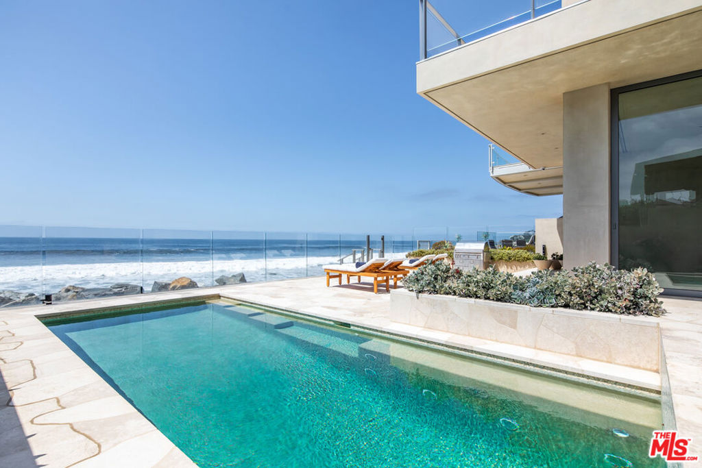 Experience the best of coastal luxury in this meticulously maintained Malibu Modern estate, perfectly situated on the coveted sands of Broad Beach. Spanning nearly 6,000 square feet adorned in elegant Venetian plaster, this four-bedroom, five-bath home offers the ideal blend of refined design and relaxed beachfront living. Flooded with natural light and framed by clean architectural lines, the open-concept layout flows seamlessly from the ocean-view living spaces to the gourmet kitchen and dining area. The oversized primary features a spacious bath with views to the ocean and a huge walk in closet. A private office and fully equipped gym provide space for work and wellness, while the attached garage ensures convenience and security. Outside, a sparkling pool and jacuzzi invite moments of leisure, all set against a backdrop of the Pacific Ocean just steps away. With direct, private access down to the sand, this is Malibu living at its finest. Available fully furnished or unfurnished, this exceptional property is a rare opportunity to lease one of Broad Beach's premier residences.