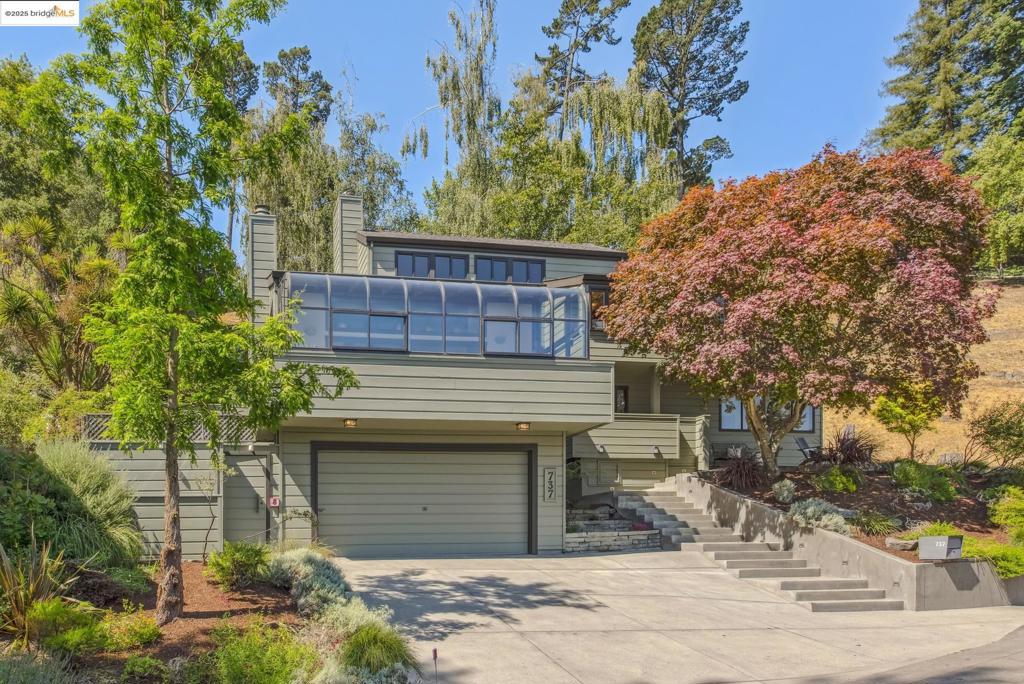 737 Woodhaven is an elegant custom designed home surrounded by nature. There are 3 bedrooms, 2.5 baths and a gorgeous family room. The living room features vaulted ceilings and opens to a large sunroom filled with light. The formal dining room is anchored by a copper light while the spacious kitchen—complete with oak cabinetry, stainless steel appliances, and a Viking professional range—overlooks the backyard. A breakfast nook and adjacent mud and laundry room complete this hub of the home. On the main level, also find one of the bedrooms and remodeled bathroom, and just a few steps up, the second bedroom facing the backyard. Enter the spacious primary en-suite from a reading corner to find a remodeled bathroom and skylights. On the top level, the family room, with a fireplace and more views, is a welcoming space to gather. On this level, also find a convenient half bath and a perfect corner for a home office. Storage is abundant with generous closets, custom built-ins throughout, and a large 2-car garage. Multiple decks wrap the home, offering distinct areas for dining, lounging, planting, or simply enjoying the quiet hillside setting. And did I mention the hot tub? Enjoy the serenity of the hills, and be in North Berkeley or Solano Ave in a mere 6 or 7 minutes (says google!).