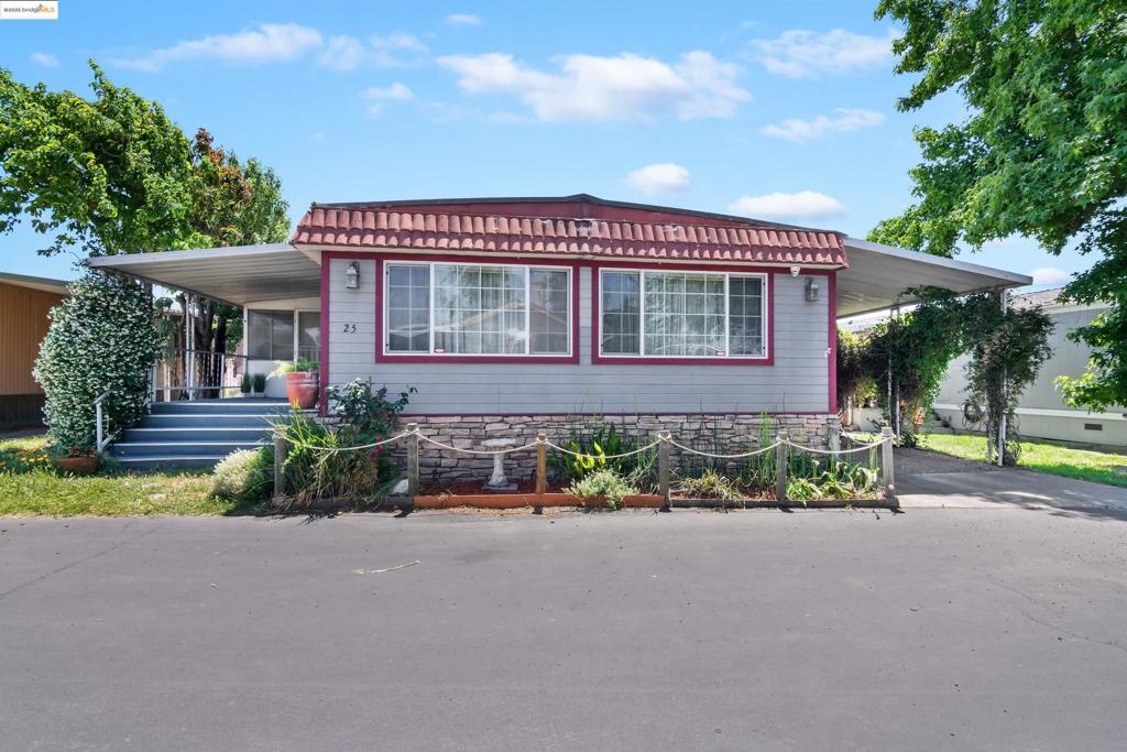 Spacious double-wide manufactured home with an enclosed patio & workshop. Over 1900 sqft including the enclosed patio. Covered carport, covered front porch, and a backyard gardener's delight! Located in Santiago Village Mobile Home Park on Bethel Island, a waterfront recreational community. Spacious mobile is 1488 sqft with 2 beds/2 baths, plus an additional 420 sqft enclosed patio & workshop, for a grand total of 1908 sqft. Includes newer windows, new carpet, textured walls, pellet stove, ceiling fans, refrigerator, washer & dryer. Living room is spacious, light & bright with natural light. Separate family room and dining room. Kitchen has double oven, gas cooktop, tile countertops and a wet bar. Dining has built in hutch, cabinets and decorative glass display shelves. Backyard includes raised garden beds w/irrigation, grapes, roses, poppies, 2 apple trees, lemon tree, asian pear and avocado. Tool shed also included. Roof has 8 years remaining on the warranty. Space Rent $893/month. Fireplaces: PST