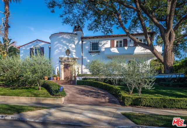 A reimagined Spanish Colonial Estate like no other. Extensively restored, this dream home showcases the charm of the 1920's with all of today's modern amenities and contemporary finishes. Downstairs features a grand 2-story entryway, stylish formal living room with original details, playful game room with built-in bar and drop-down movie projector, estately wood paneled dining room, stunning kitchen with 20 ft Carrera marble island, family room, home office, wine cellar, and maid's quarters. Tall glass paneled doors open to the backyard offering great indoor/outdoor entertaining. Multiple outdoor seating areas surround the property including a gorgeous terrace that overlooks the beautiful landscaped garden complete with pool, spa, built-in BBQ and fountains. Upstairs features 5 bedroom suites and a rooftop deck. Huge master with fireplace, his/her baths and separate walk-in closets. Trophy property on nearly half an acre with views of the golf course. Gated parking for 6 cars.