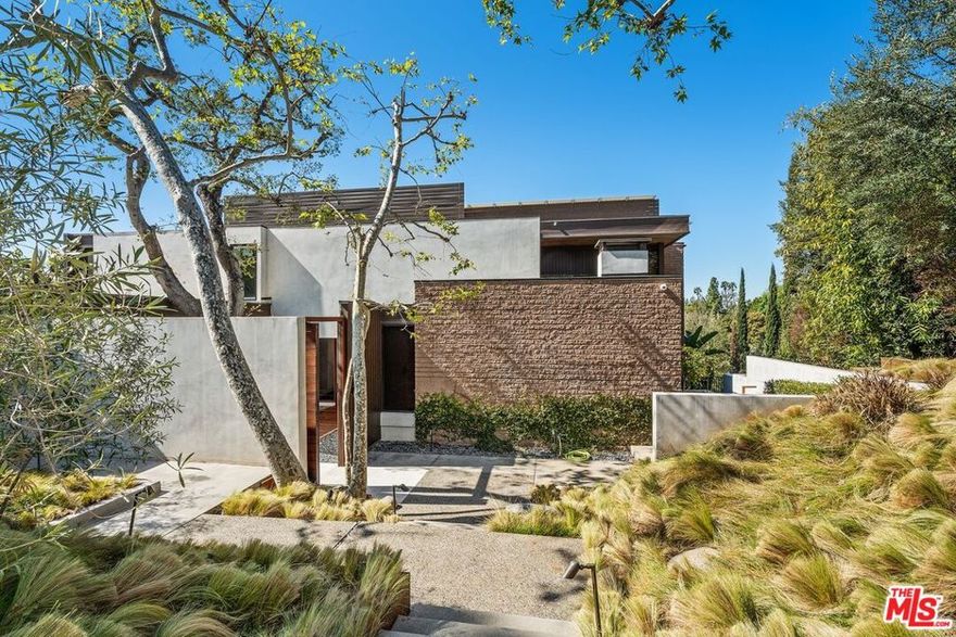 Nestled on a quiet cul-de-sac in one of the most prestigious neighborhoods of Beverly Hills, just above the iconic Beverly Hills Hotel and adjacent to the historic Virginia Robinson Gardens, this extraordinary architectural estate offers a rare opportunity to own a home that is both timeless and thoroughly modern. Originally designed by noted architect Robert Skinner, AIA, this residence has been completely reimagined through an extensive multi-year renovation, blending mid-century modern elegance with contemporary sophistication and luxurious finishes throughout.Set behind private gates, the property spans approximately 28,824 square feet of land, nearly three-quarters of an acre, with an expansive motor court, mature landscaping, and commanding presence. With over 6,000 square feet of interior living space, this five-bedroom, six-bathroom home was curated for those who appreciate thoughtful design, grand scale, and seamless indoor-outdoor living.Upon entry, guests are greeted by a dramatic foyer and soaring 22-foot ceilings in the formal living room. Walls of glass flood the space with natural light and open to panoramic tree-top and city views. A striking copper-faced fireplace anchors the living space, offering both warmth and a bold architectural statement. The open floor plan flows effortlessly into the formal dining room, family/media room, and a sophisticated office, creating ideal spaces for entertaining or quiet reflection.The heart of the home is a state-of-the-art chef's kitchen, featuring a large center island, custom cabinetry, professional-grade appliances, and an adjacent breakfast area that opens directly to the outdoors. Every room has been designed with intentionality and flow, utilizing the finest materialsfrom hand-selected stone to custom millwork and designer lighting.The primary suite is a true retreat, offering a tranquil escape with views stretching out over the city. It includes a luxurious spa-like bathroom with dual vanities, soaking tub, walk-in shower, and an oversized custom walk-in closet. Four additional guest bedrooms provide ample space for family and visitors, each appointed with designer finishes and private outlooks.No detail was overlooked in the comprehensive $9 million+ renovation. The entire home has been updated with today's most desirable features, including smart home integration, advanced lighting and sound systems, and energy-efficient design elements that enhance comfort and style.The outdoor living experience is unparalleled. Designed to feel like a private resort, the grounds feature a newly constructed zero-edge pool and spa, multiple terraces for sunbathing or entertaining, and beautifully landscaped pathways that guide you through lush gardens and tranquil sitting areas. A rare, regulation-size north-south tennis courta coveted luxury in Beverly Hillssits below the home, surrounded by tall hedges and mature trees, offering both beauty and privacy.This is a property that embodies elegance, privacy, and sophistication in every sense. Its locationjust minutes to the best of Beverly Hills yet tucked away in a serene, hidden settingmakes it one of the most desirable offerings on the market today. With its architectural pedigree, world-class renovations, and unparalleled outdoor amenities, this home is more than a residenceit is a work of art designed for refined living.