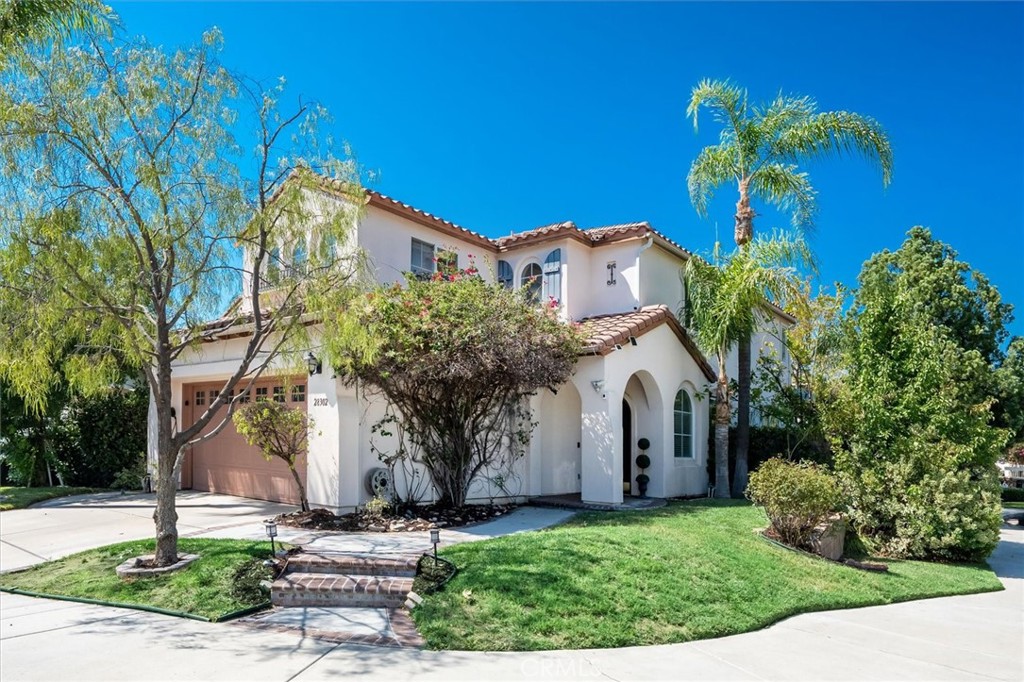 Updated Wildrose home in Valencia Northpark, perfectly situated on a corner lot! The freshly painted interior features gleaming hardwood floors downstairs, raised baseboards, recessed lighting, and a cozy fireplace in the family room. The spacious, updated kitchen includes quartz counters, a large center island with breakfast bar, and opens to the family room with a raised hearth and home projector system—perfect for movie nights.
Upstairs you’ll find four bedrooms, including a primary suite with a walk-in closet and private bathroom, plus a versatile landing area ideal for a home office. The backyard offers a patio, mature trees, and lush landscaping for a private retreat. Additional highlights include an indoor laundry room, ceiling fans, plenty of storage, and smart home features that allow you to control lights, temperature, and the front door remotely.
Enjoy all the Northpark amenities including Valencia paseos, clubhouse, three pools, tennis courts, and award-winning schools. HOA is $59 per month and no Mello Roos.