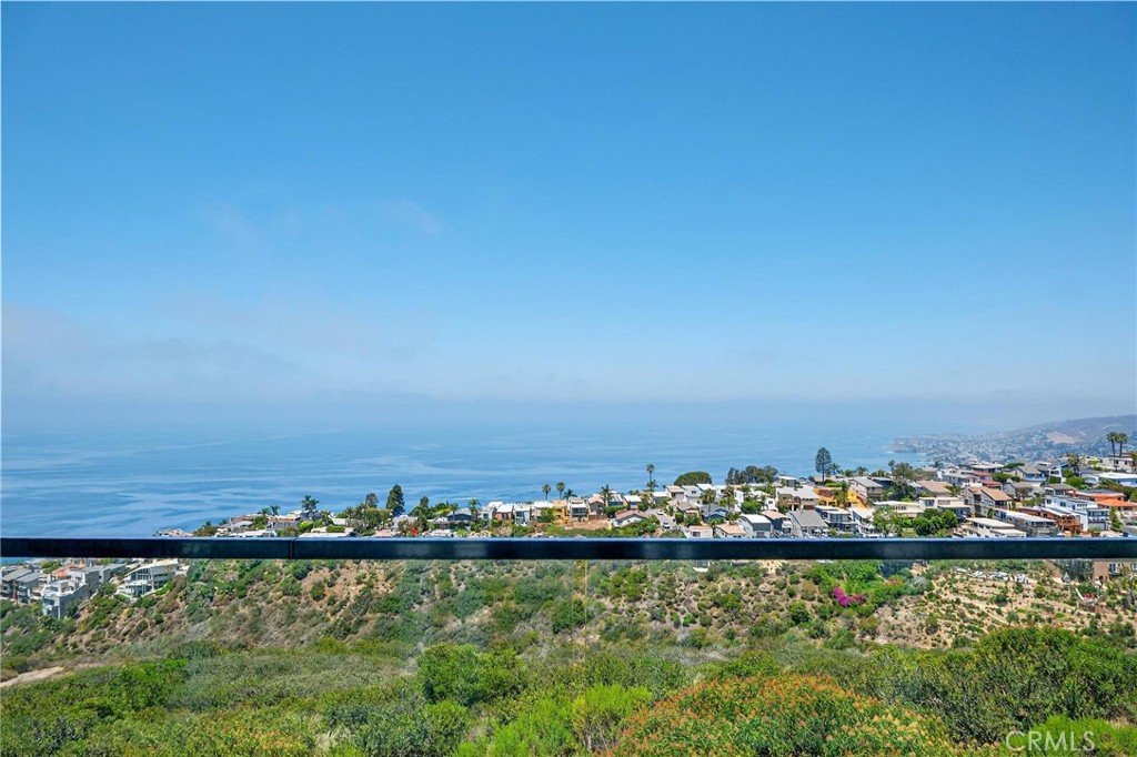 Set in the hills of Arch Beach Heights, this one-of-a-kind multi-level Laguna Beach home offers sweeping panoramic views of the ocean, Catalina Island, coastline, and sparkling city lights from every level. Beautifully remodeled and move-in ready, this rare gem is perfectly positioned on an oversized 1.5-lot parcel, delivering the ideal blend of coastal luxury and laid-back charm. The main level welcomes you with an open-concept floor plan designed for seamless entertaining. A spacious living room and dining area flow effortlessly to a large ocean-facing balcony through expansive glass doors, creating a true indoor-outdoor experience. The designer kitchen is fitted with custom cabinetry, high-end quartz countertops, and premium appliances—crafted to satisfy both form and function. Upstairs, the primary suite offers a peaceful retreat complete with a private ocean-view balcony, a remodeled spa-style bathroom, a walk-in closet, and a second custom wardrobe for added space. Thoughtful upgrades throughout the home include engineered hardwood flooring, custom doors, recessed lighting, energy-efficient windows, and a new heating system with WiFi-enabled controls. Travertine marble lines the staircases and hallway, adding a touch of timeless elegance. The lower level features a private guest suite with its own entrance, bedroom, walk-in closet, and full bath—ideal for visiting family or potential rental income. The exterior is finished with smooth stucco, modern motion-sensor lighting, and tasteful landscaping that enhances both privacy and curb appeal. Just minutes from iconic beaches, scenic hiking trails, upscale dining, art galleries, and world-renowned resorts, this turnkey property captures the essence of Laguna Beach living—offered at a price that’s sure to generate serious interest.