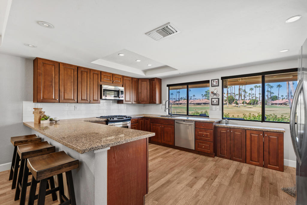Welcome to this beautifully remodeled El Grande model condo at the desirable Chaparral Country Club. Perfectly situated on two golf holes, the home enjoys one-of-a-kind views--perched above a golf green with a sparkling lake beyond, framed by breathtaking mountain vistas. To the side, you'll overlook an additional tee box for a long par-4 hole, all while being safely tucked away from errant golf balls.Inside, the stunning kitchen is a showstopper. Thoughtfully redesigned with a wall removed, it now offers a seamless open flow, high-end appliances, custom cabinetry, and an ideal space for both cooking and entertaining. The living areas are enhanced with luxury vinyl ''wood'' flooring, while plush carpet adds comfort to each of the three bedrooms and bathrooms.Additional upgrades include:Epoxy-coated garage with built-in cabinetry and sinkRecently upgraded HVAC system and water heaterSpacious layout designed for modern livingAcross the street, you'll enjoy open views toward the mountains, with the driving range set well below sightline for a peaceful, expansive feel.At Chaparral Country Club, residents enjoy resort-style amenities: 18 holes of golf, numerous pools and spas, tennis, pickleball, a fitness center, and a welcoming clubhouse for dining and social gatherings.This is truly a rare opportunity to own a move-in ready, view-rich home in one of the desert's most sought-after country clubs.