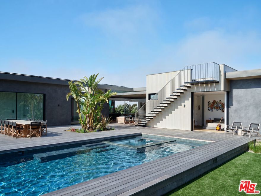 Coastal Modernism on Point Dume | Main Residence + Guest House! Welcome to a stunning example of Coastal Modernism; Malibu's new class of design-forward living. Set behind private gates and thoughtfully positioned back from the road for exceptional privacy, this newly built estate captures the essence of contemporary California architecture, where clean lines, natural textures, and light-filled volumes create an effortless harmony between home and landscape. The main residence features 4 bedrooms and 4.5 bathrooms across expansive, open living spaces framed by Sky-Frame, Swiss-engineered floor-to-ceiling glass doors, allowing for seamless transitions between indoors and out. Every detail has been curated with precision custom millwork, Venetian plaster walls, imported stone surfaces, wide-plank oak floors, and designer lighting all speak to elevated taste and enduring craftsmanship. The chef's kitchen blends form and function with premium appliances, a striking island, and bespoke cabinetry. The primary suite serves as a private retreat, offering a spa-style bathroom with a soaking tub and a terrace overlooking the lush grounds. Smart-home technology is fully integrated throughout, including smart toilets, a solar generator system, and energy-efficient design that reflects a commitment to sustainability and modern comfort. The outdoor living experience serves as an architectural extension of the home, featuring multiple entertainment areas, a veranda with TV and fireplace, expansive decks overlooking the landscaped grounds and ocean views, and a cozy firepit seating area. A rooftop deck with firepit, pool, spa, and pool house completes the resort-style ambiance. The pool house includes a full bathroom, custom-designed Murphy bed, steam shower, and a fully equipped gym, all surrounded by landscaping designed for privacy, relaxation, and entertaining. A 2 bedroom 2.5 bathroom guest residence complements the main home with equal sophistication. Featuring high ceilings, hardwood floors, Fleetwood pocket doors, and a loft with an office, it provides independent living while maintaining architectural unity with the main house. Outdoor decks, a detached office with half bath, private spa, outdoor shower, and firepit complete this beautifully considered space. Located in Point Dume, one of Malibu's most sought-after neighborhoods, this estate includes coveted beach key access to Little Dume Beach, celebrated for its natural beauty, world-class surf breaks, and serene coastal setting. Just minutes from Malibu's best dining, markets, and schools, this property embodies the pinnacle of modern coastal living, architecturally significant, thoughtfully built, and designed to connect deeply with both the land and the ocean. The estate also features a three-car garage, vegetable garden, and dedicated basketball/pickleball area, making it a complete expression of Malibu luxury, lifestyle, and design. Please note: The property is currently leased at $50,000 per month, which excludes the 1,300 SF detached 2BD/2.5BA guest house. The new offering price at $62,000 includes the entire property.