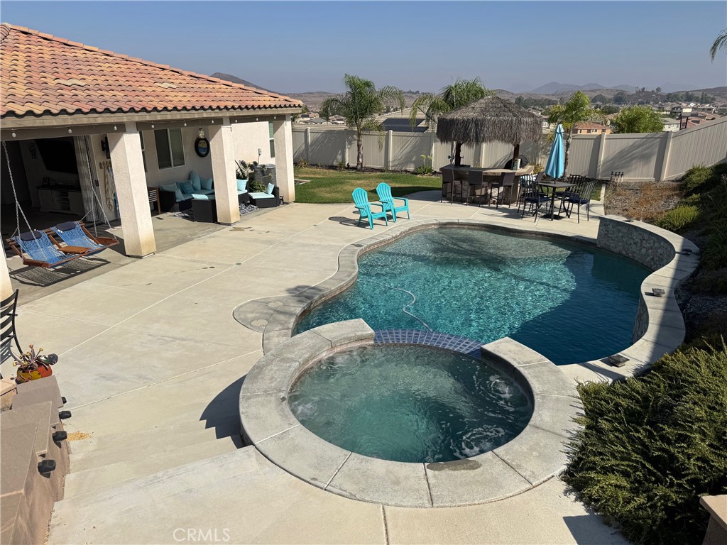 FOR LEASE – Resort-style living at its best! This stunning 3-bedroom, 3-bathroom home offers 2,091 square feet of living space on a spacious 13,504 sq. ft. lot. The backyard is an entertainer’s dream, featuring a free-form pool, elevated spa, gas firepit, covered patio, and a palapa complete with a Blaze BBQ, mini-fridge, and keg option. There is also room for potential RV or trailer parking, along with the privacy you’ll love. Inside, the family room opens fully to the backyard through beautiful sliding glass accordion doors, creating a seamless indoor-outdoor living experience. The kitchen is appointed with stainless steel appliances, an island, quartz counters, and laminate flooring. All three bathrooms are upgraded with granite counters. The primary suite includes a walk-in closet with custom shelving, while the two additional bedrooms are located on the opposite side of the home for added privacy. Additional highlights include solar power (additional $150, bringing the gross rent to $4,050), a Tesla charger in the garage, and included washer, dryer, and refrigerator. Rent also covers internet, pool service, landscaping, and HOA fees. This home truly offers the perfect combination of comfort, luxury, and efficiency—an opportunity not to be missed! $4,050 GROSS RENT INCLUDING SOLAR.