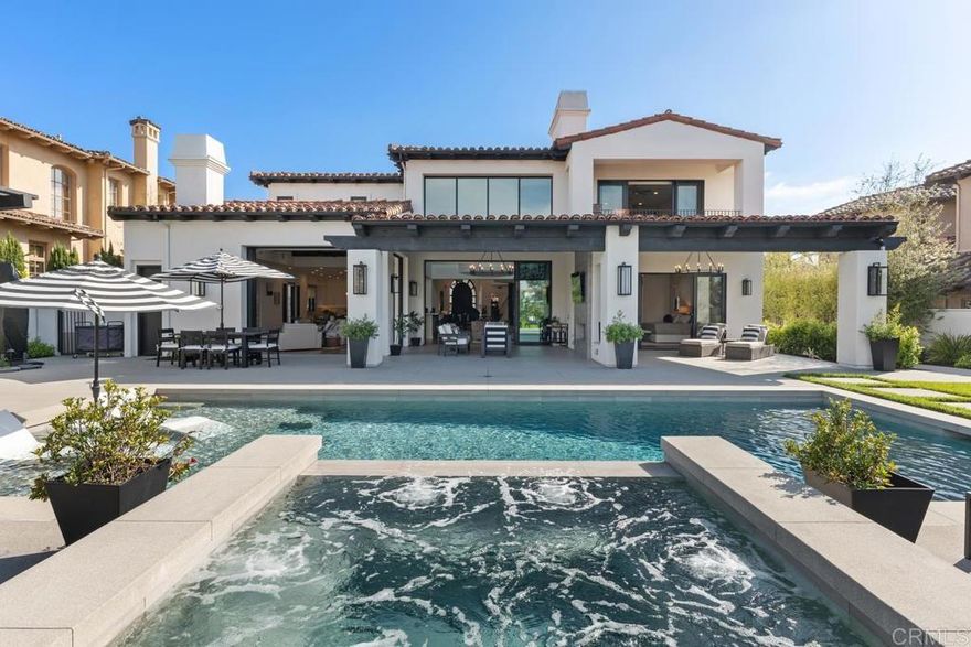 In the prestigious gated enclave of Meadows Del Mar, this curated 6,619 sq ft residence is a masterclass in modern elegance, comfort, and inspired design. Thoughtfully remodeled, every space tells a story—of smart living, creative entertaining, and heartfelt gatherings.  The grand entry sets the tone, opening into a lifestyle where form meets function at every turn. Entertain effortlessly in the conversation den under soaring box beam ceilings, or pour a glass from the dual custom wine cellars and step up to the intimate entertainment bar. The chef’s kitchen—with its expansive island, Wolf and Sub-Zero appliances—flows into a warm family room, making connection feel effortless.  With five bedrooms plus a private office (with a separate entrance), the layout is as versatile as it is spacious. The luxurious downstairs primary suite offers his and her closets, a spa-like bath, and private loggia access with a fireplace—the perfect retreat.  Designed for both lively gatherings and quiet moments, the outdoor spaces echo the resort living. Covered loggias invite afternoon naps and twilight conversations, while the California room with fireplace and a full outdoor kitchen set the stage for unforgettable evenings. The modern pool and raised spa overlook the lush greens of the Grand Del Mar Golf Course, completing the picture of effortless luxury. This home isn’t just a place to live—it’s a place to love, laugh, and create memories for years to come.