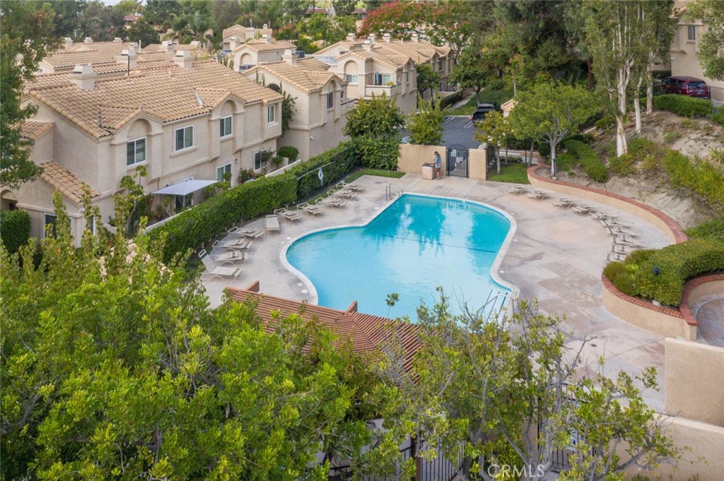 Immaculate end-unit townhome in the sought-after Vista Del Flores community—no one above or below! This light-filled home offers spacious rooms, an open floor plan, and thoughtful upgrades throughout. The inviting living room features a cozy fireplace and flows seamlessly into the kitchen, complete with ample cabinetry, generous counter space, and stainless-steel appliances including a gas range, microwave, and dishwasher. The dining area overlooks the private, enclosed patio—perfect for outdoor entertaining or relaxing. Luxury vinyl tile flooring extends through the main level and all bathrooms. Upstairs, you’ll find dual primary suites, each with its own ensuite bathroom. Convenient laundry closet with full-size washer and dryer hookups is also located on the bedroom level. A downstairs powder room adds extra functionality. The oversized two-car garage is a dream for hobbyists or handy folk, complete with a wraparound workbench. Just outside, enjoy the charming brick patio with views of the community amenities—pool, spa, playground, and guest parking—all just steps away. This townhome truly has it all. Don’t miss the chance to call it home!