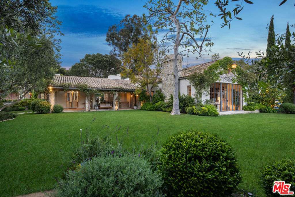 Surrounded by nature and bathed in natural light, this romantic estate is set on 2/3 of an acre in an ultra-exclusive enclave of Sullivan Canyon. Through the walled and gated entrance, you're met with lush landscaped gardens and grounds that whisk you away to the pages of a storybook. The original home was designed by legendary architect Cliff May and has since been reimagined by noted architect Steve Giannetti with interior design by Kelly Harmon. The main house features an open floor plan with soaring wood-beamed ceilings and garden views throughout. Organic flow through the main living spaces to the chef's kitchen. 4 spacious bedrooms in addition to the serene primary suite featuring a fireplace, steel windows and doors that open out to the gardens. Ascend a flight of stairs to a spacious office with fireplace. As an equestrian estate, the grounds are complete with stables, a walking ring, and a tack room. Additional outdoor amenities include a pool, spa, and 2-story guest house. Conveniently close to the Brentwood Country Mart, both Riviera and Brentwood Country Clubs, as well as Sunset Boulevard. This estate is the epitome of a garden retreat in an ultimate private and luxurious setting.
