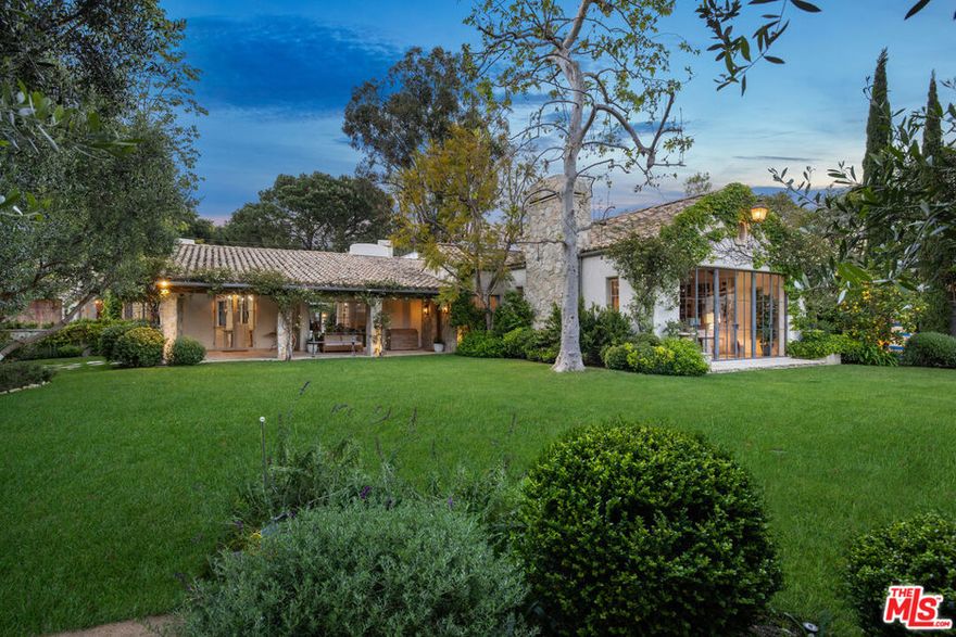 Surrounded by nature and bathed in natural light, this romantic estate is set on 2/3 of an acre in an ultra-exclusive enclave of Sullivan Canyon. Through the walled and gated entrance, you're met with lush landscaped gardens and grounds that whisk you away to the pages of a storybook. The original home was designed by legendary architect Cliff May and has since been reimagined by noted architect Steve Giannetti with interior design by Kelly Harmon. The main house features an open floor plan with soaring wood-beamed ceilings and garden views throughout. Organic flow through the main living spaces to the chef's kitchen. 4 spacious bedrooms in addition to the serene primary suite featuring a fireplace, steel windows and doors that open out to the gardens. Ascend a flight of stairs to a spacious office with fireplace. As an equestrian estate, the grounds are complete with stables, a walking ring, and a tack room.  Additional outdoor amenities include a pool, spa, and 2-story guest house. Conveniently close to the Brentwood Country Mart, both Riviera and Brentwood Country Clubs, as well as Sunset Boulevard. This estate is the epitome of a garden retreat in an ultimate private and luxurious setting.